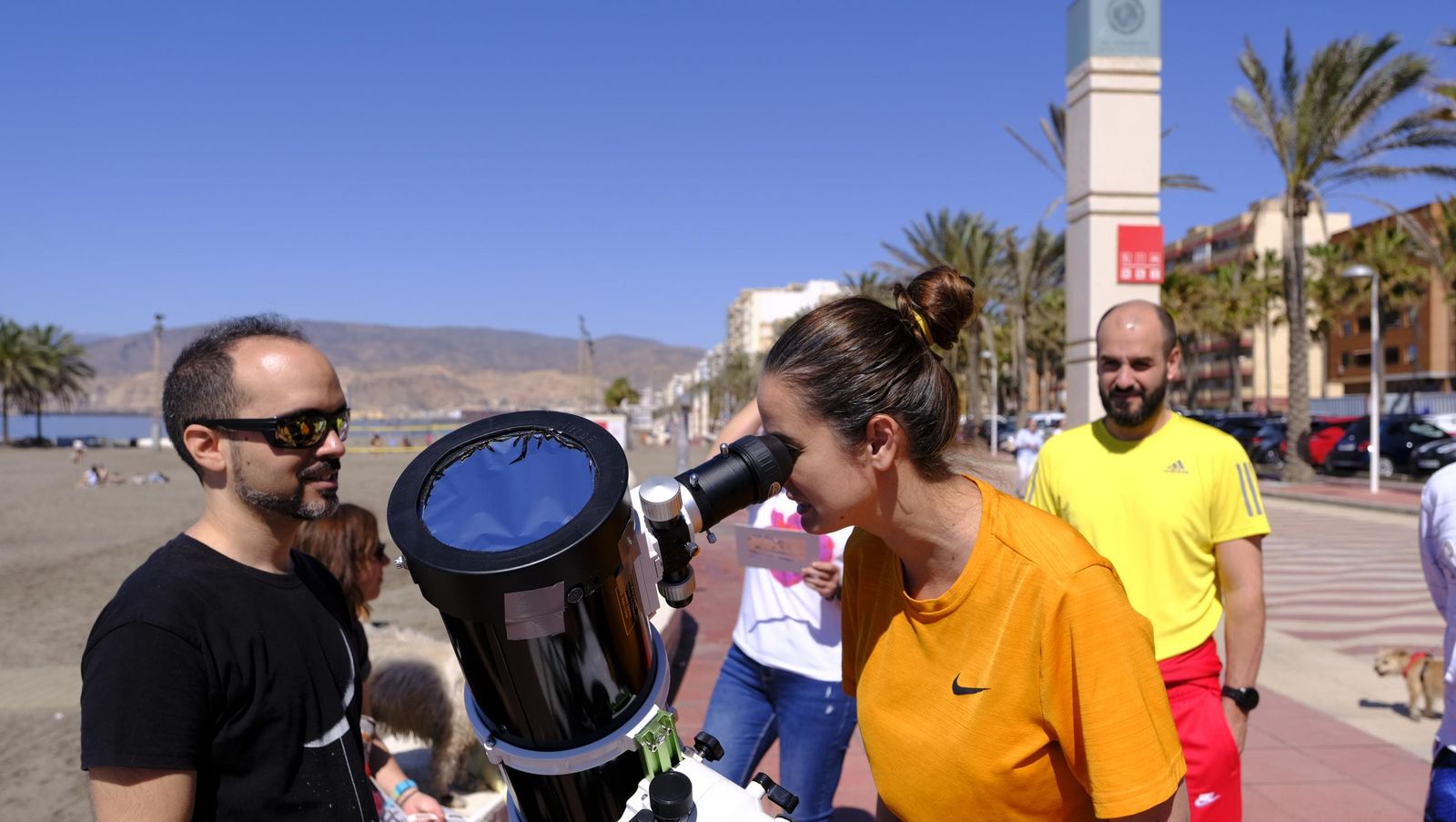 Almería observa el eclipse solar desde el Paseo Marítimo, en imágenes