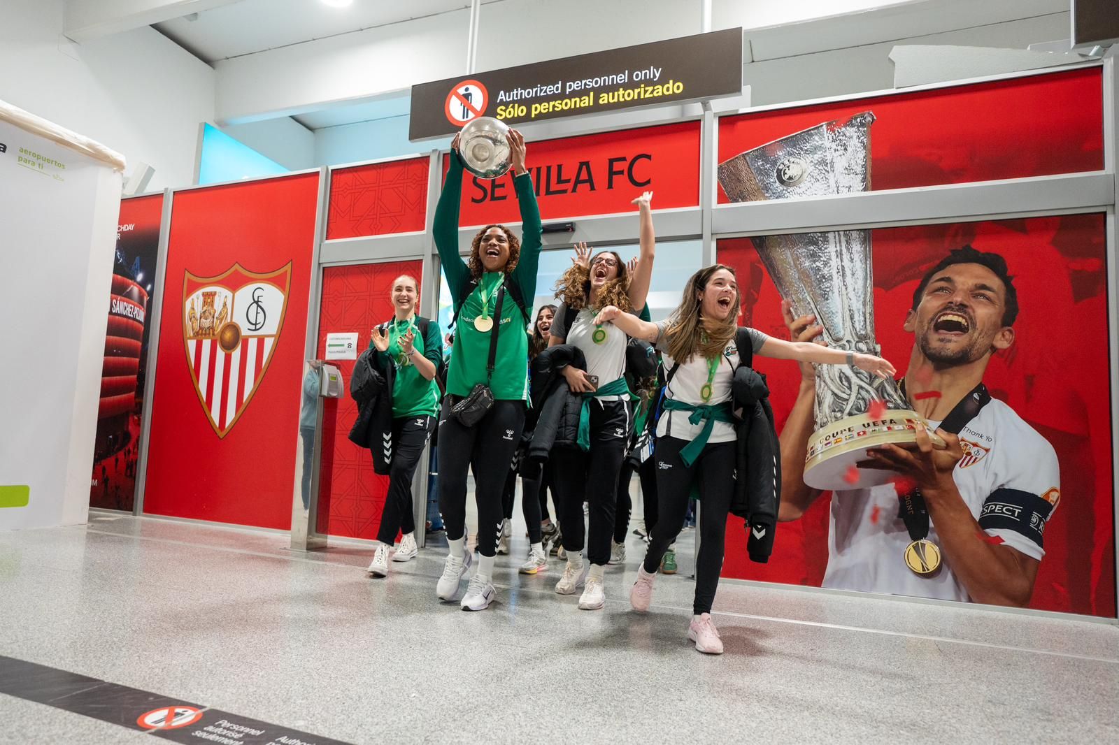 Maguilaura Frías sale eufórica a la terminal del Aeropuerto de Sevilla con la Copa de la Reina.