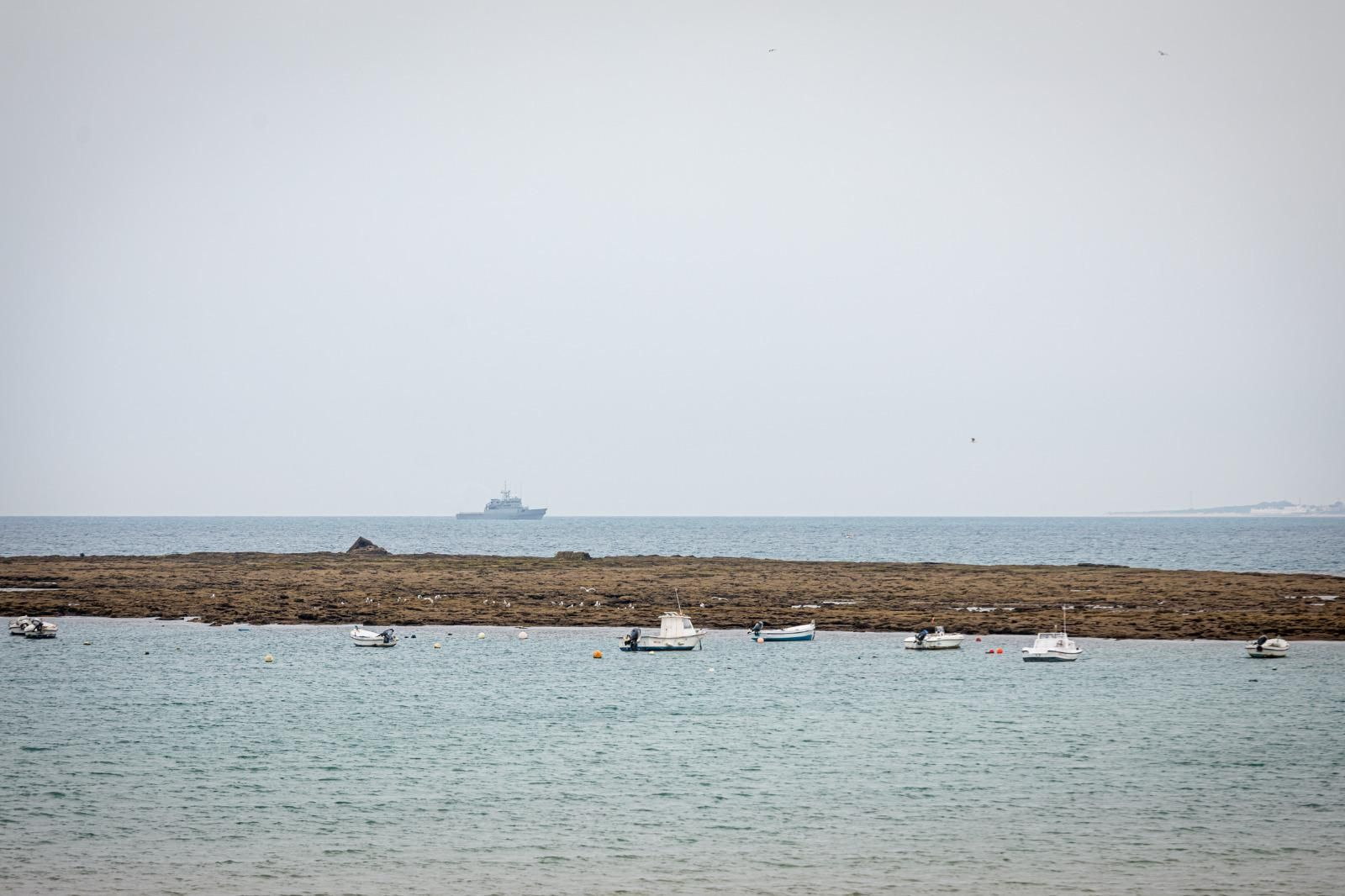 El horizonte marino, visto desde la  playa de La Caleta, de Cádiz, con la costa roteña a la derecha.