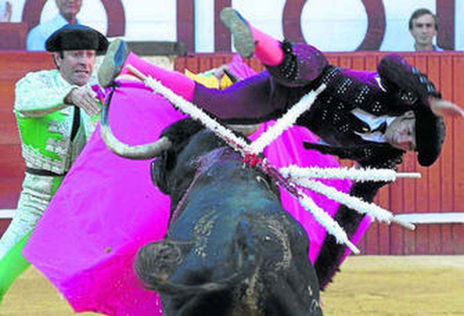 El toro encampanando al banderillero Curro Robles, herido grave ayer en la plaza de Málaga.