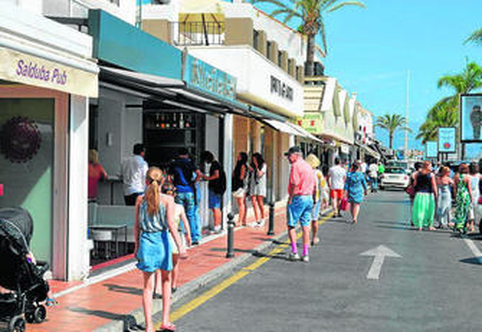 Los turistas recorren el paseo marítimo.
