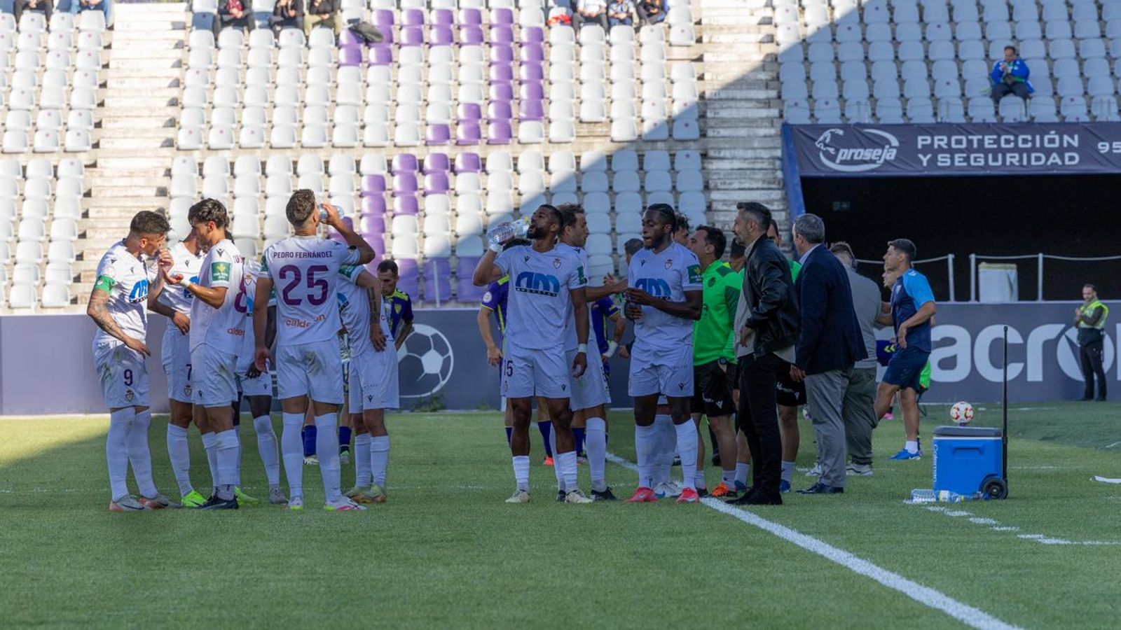 Manolo Herrero da indicaciones a varios de sus jugadores en la pausa por hidratación.