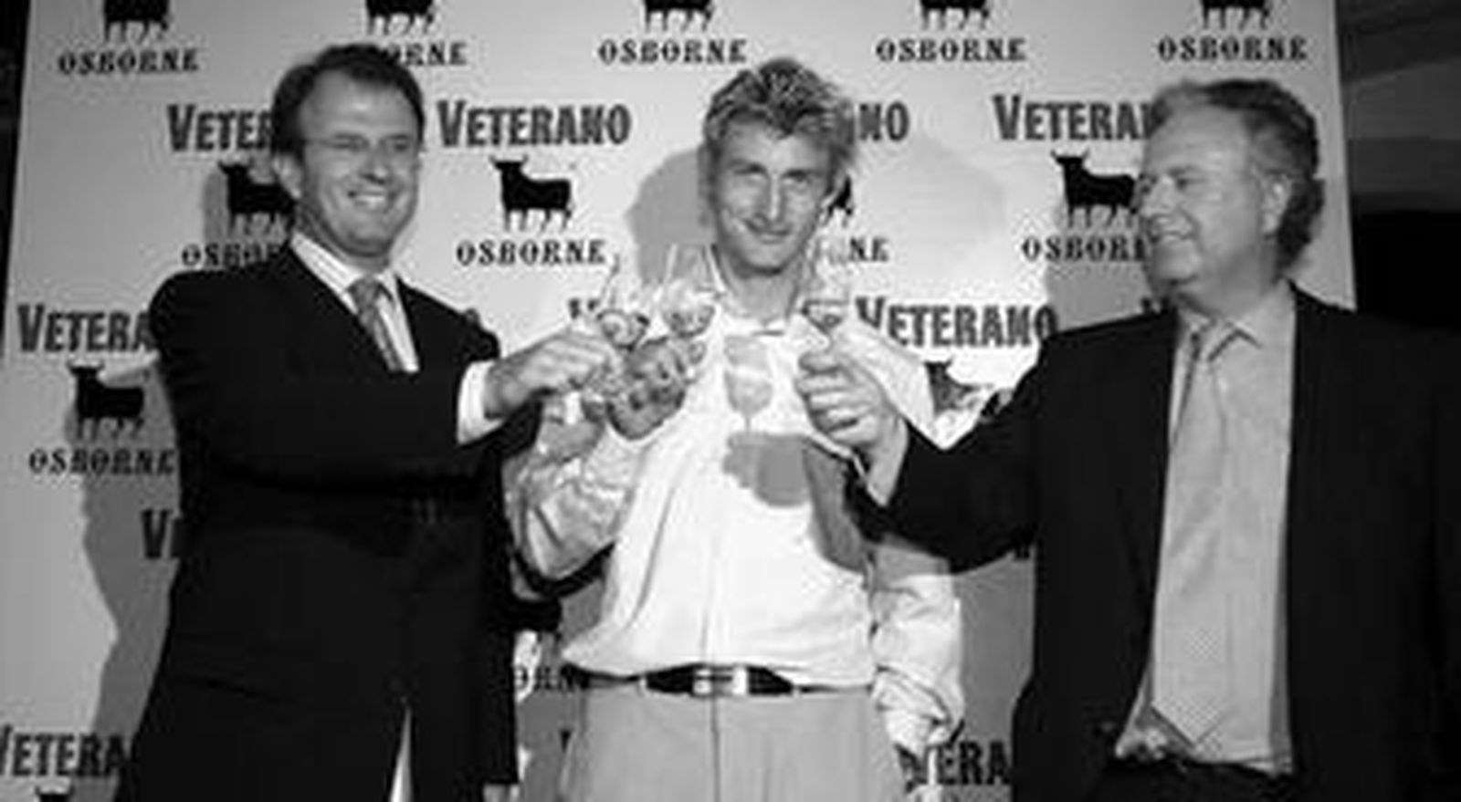 Los dos primos, Ignacio y Tomás, brindan con el tenista Juan Carlos Ferrero en un acto de la compañía en el año 2004.