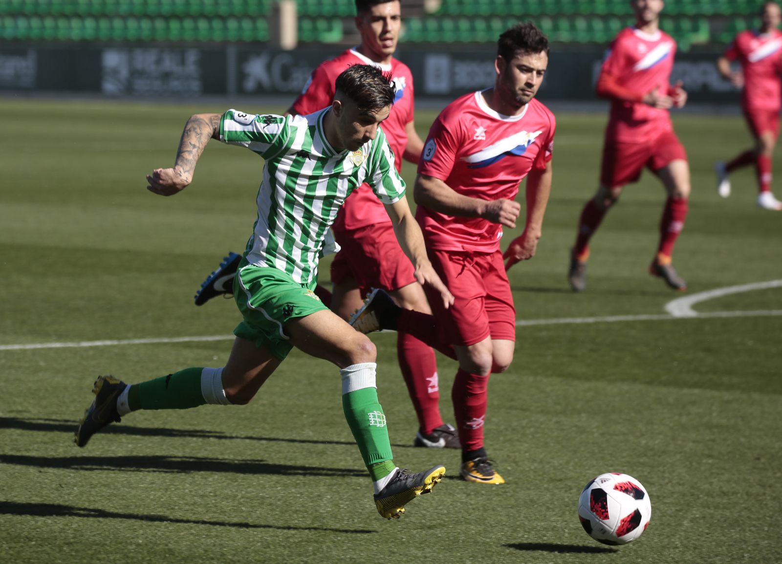 El bético Roberto intenta marcharse de un rival.