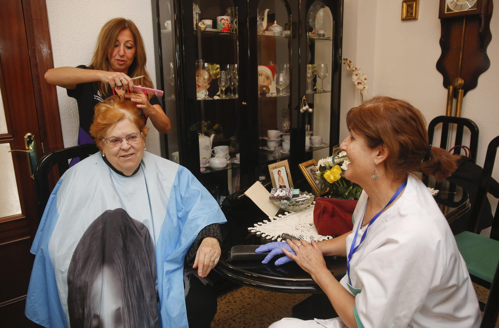 Rosa María le corta el pelo a Pilar en su domicilio.