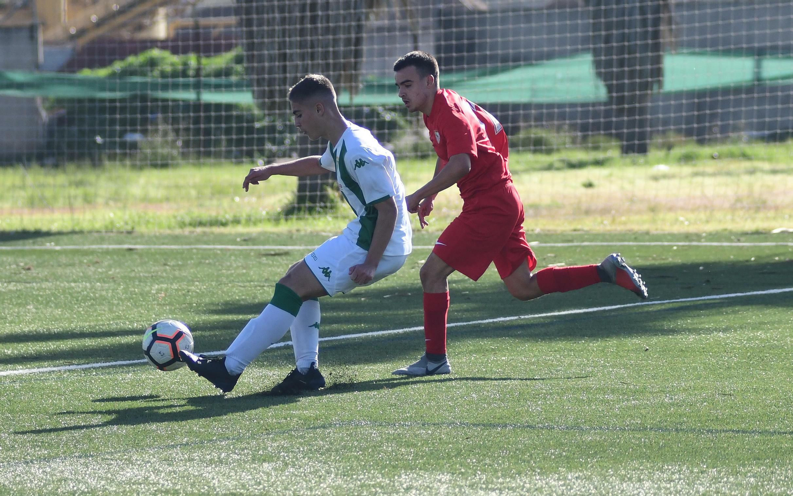 Un jugador del Córdoba pasa el balón en presencia de un rival del Sevilla.