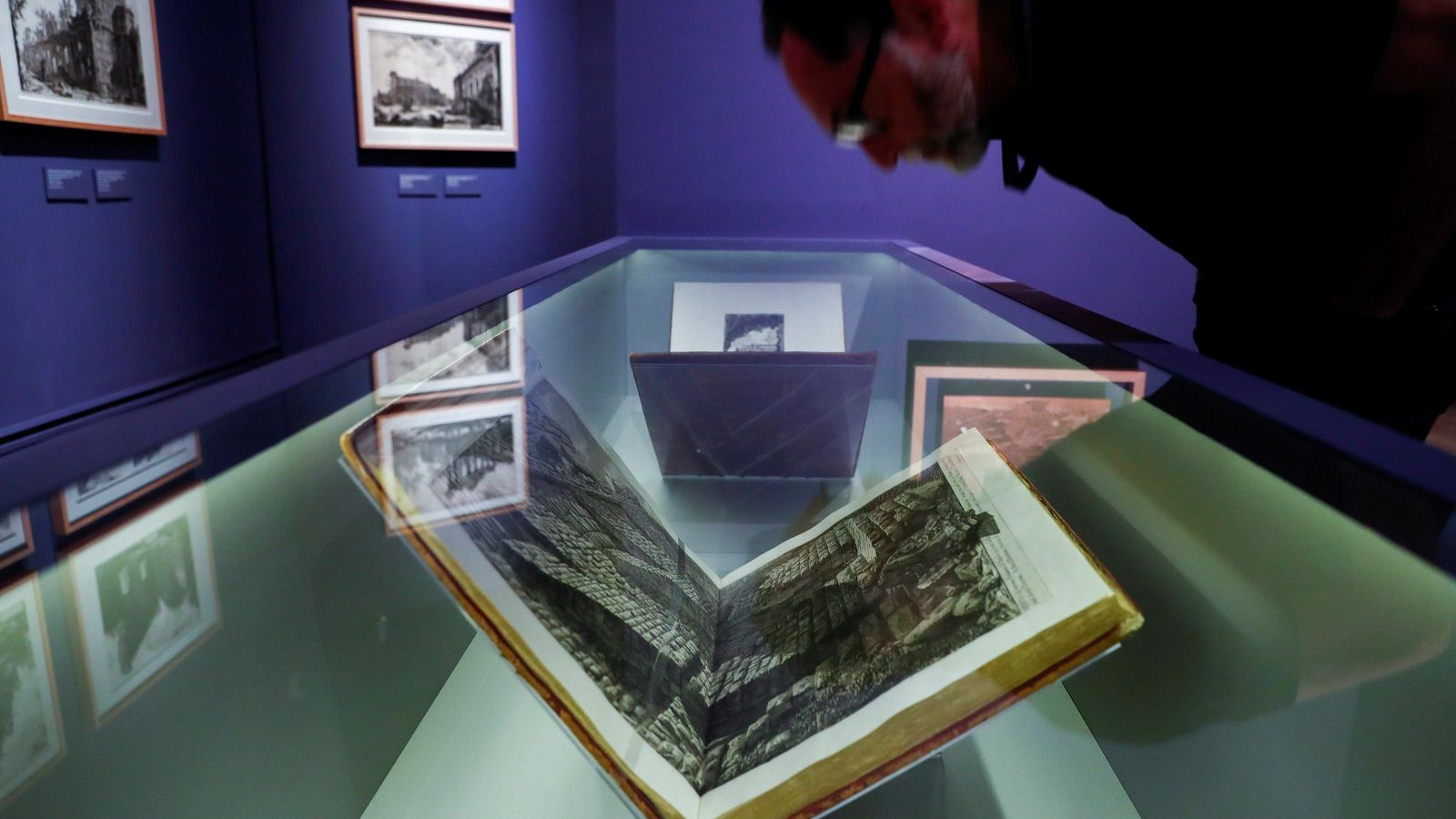 Un visitante contempla de cerca uno de los famosísimos grabados del artista veneciano.