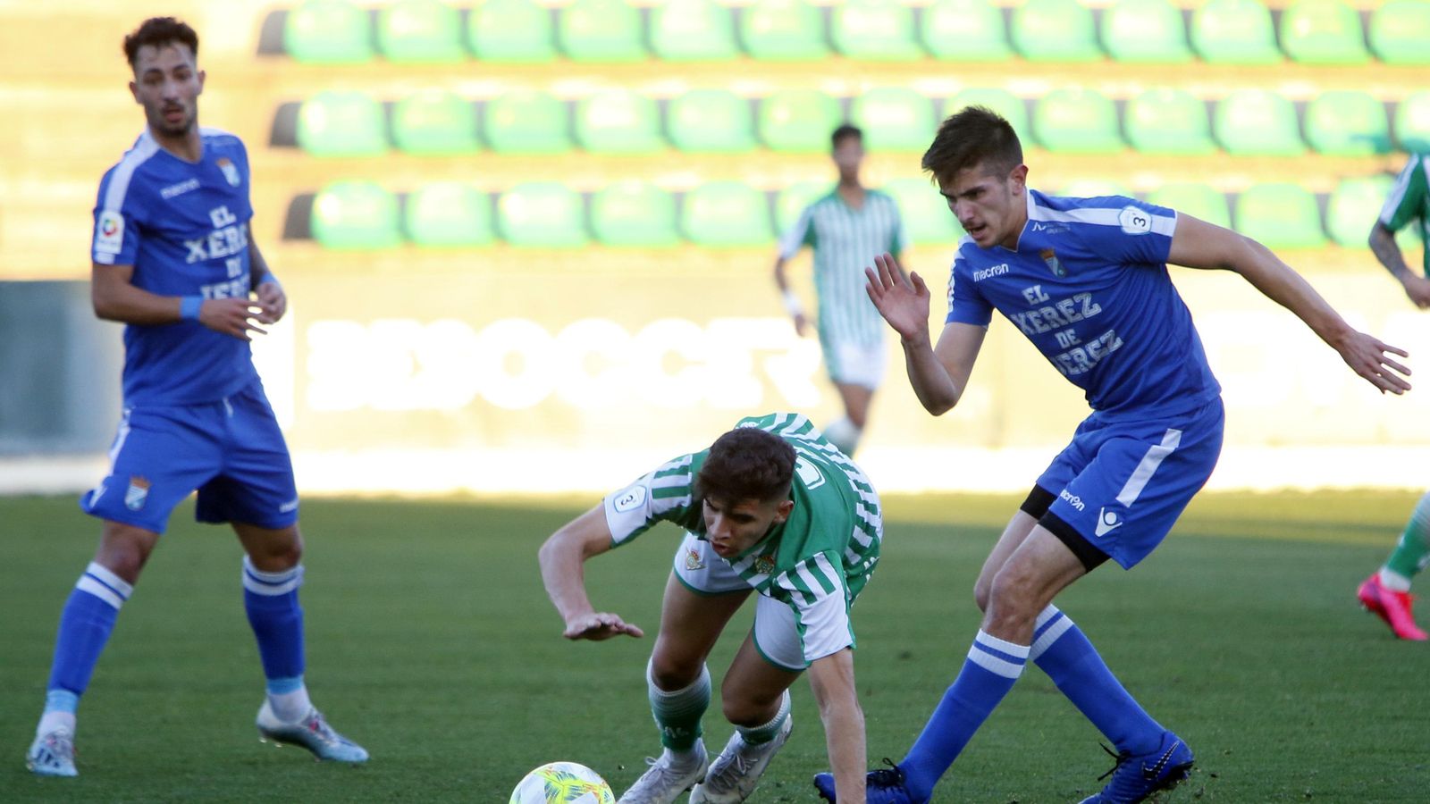 Álex Revuelta pelea por un balón con un jugador bético.