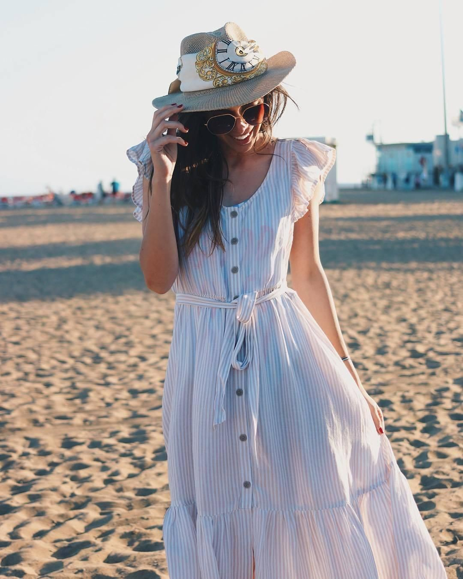 Silvia de Benito nos regala esta estampa playera con este vestido midi de popelín a rayas con volantes en los hombros y en el bajo. El pañuelo que lleva alrededor de su sombrero de yute le da un aire de Alicia en el País de las Maravillas a la foto.