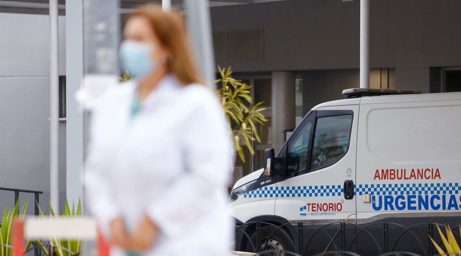Una sanitaria frente a una Ambulancia en la entrada de un Hospital.
