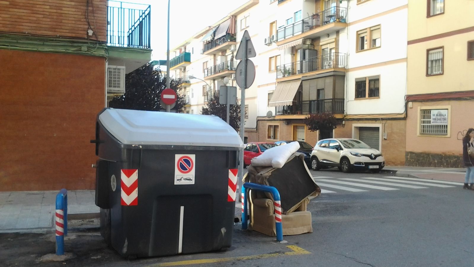 Muebles junto a un contenedor en una calle de la capital onubense