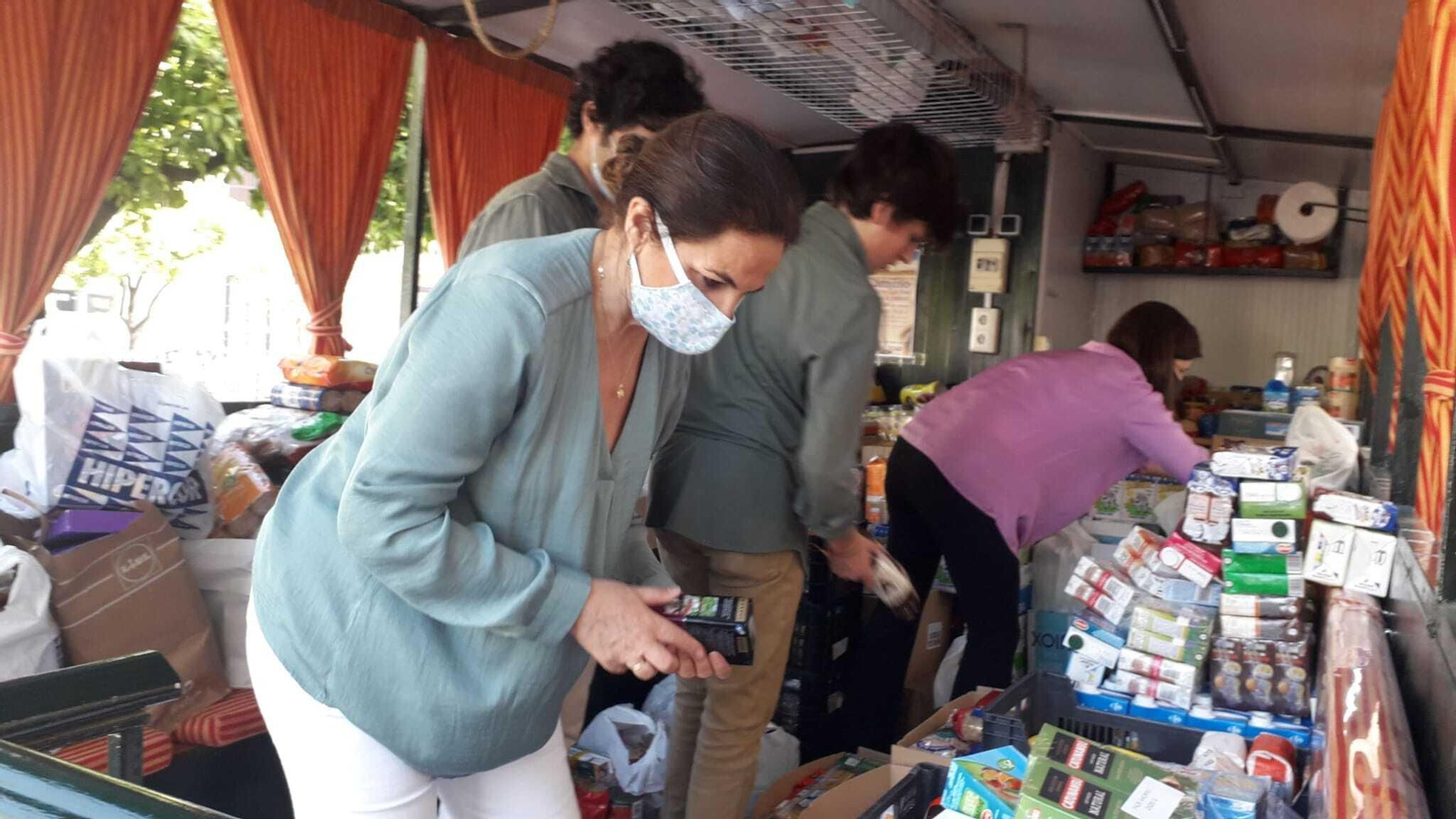 Una mujer, con mascarilla, en el interior de la carreta.