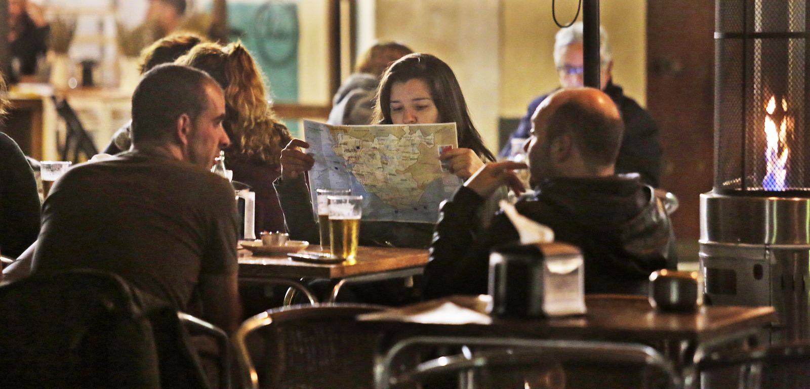 Una joven consulta un mapa de la provincia en una terraza de El Puerto.