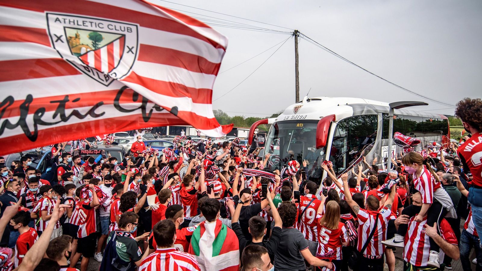 Una bandera del Athletic y multitud de aficionados en Lezama.