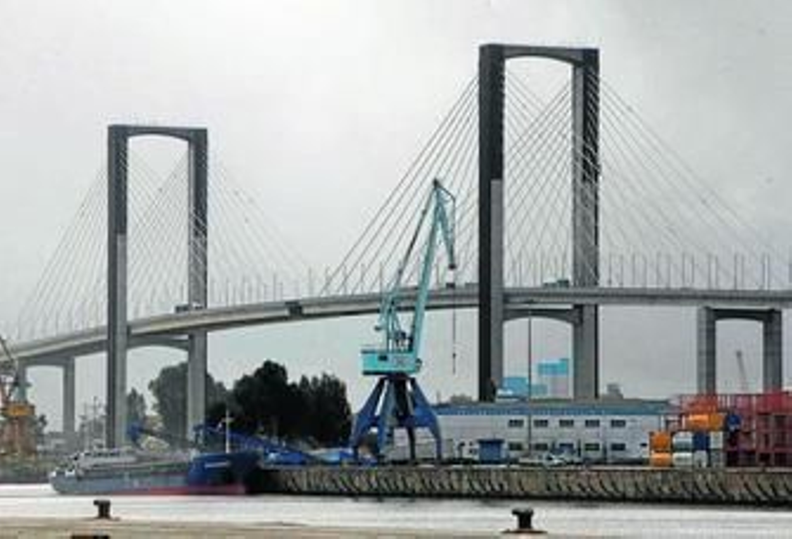 Vista general del Puerto de Sevilla con el puente del V Centenario al fondo.