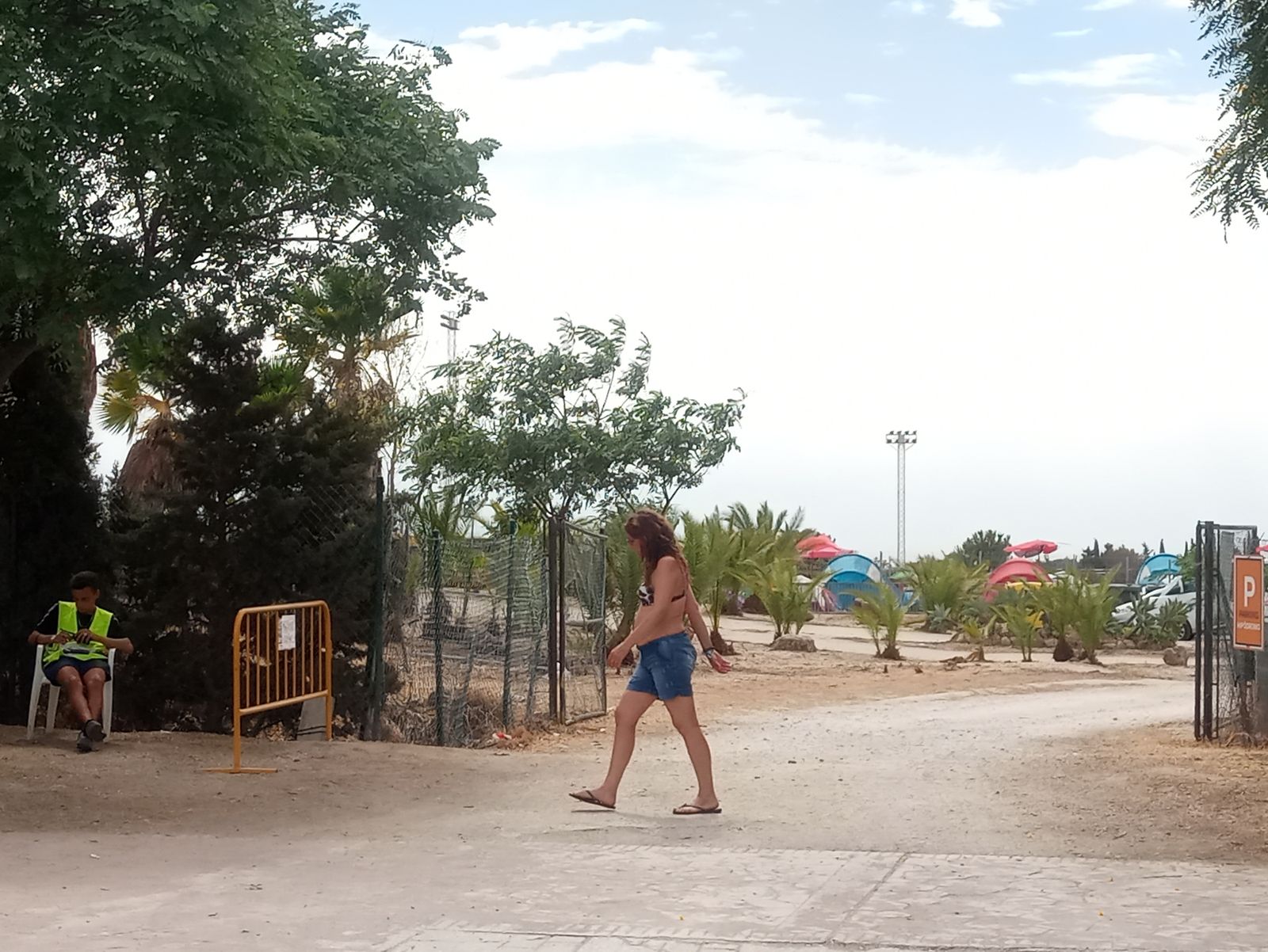 Una joven camina por la entrada del camping del festival Cala Mijas.