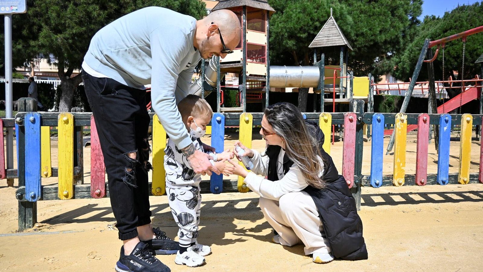 Los padres limpian las manos de Fabio tras una mañana de juegos en el parque.