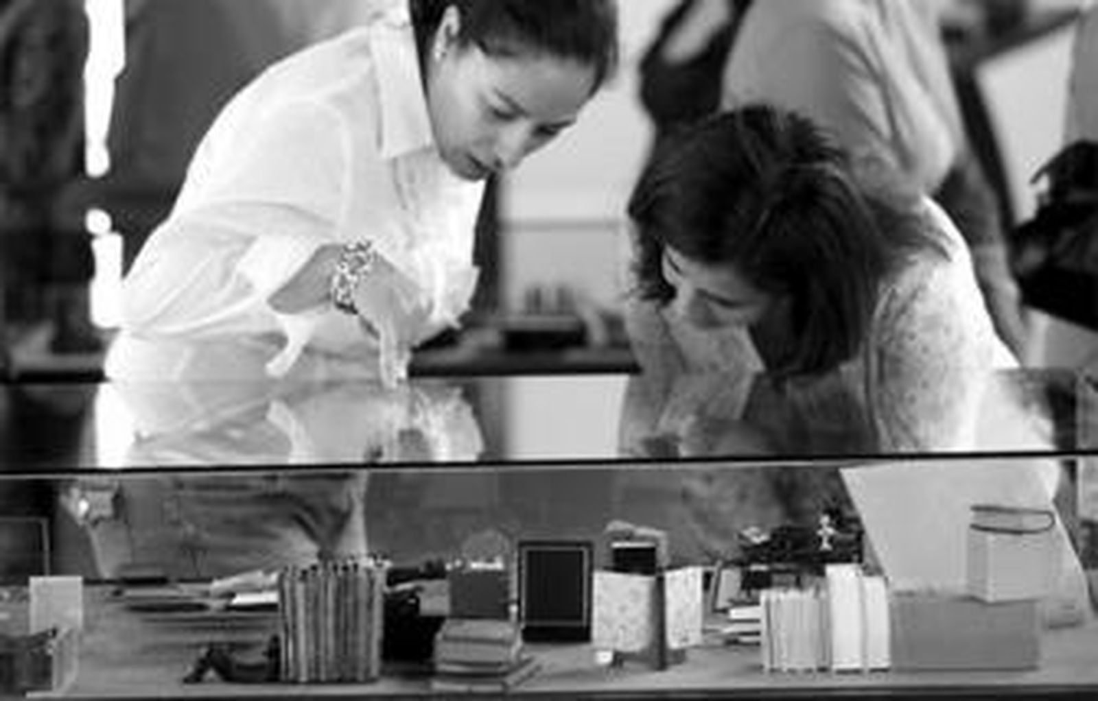 1. Unas visitantes observan la vitrina dedicada a Poética, que incluye los llamados Libros para damas. 2 y 3. Dos de los ejemplares más pequeños que recoge esta exposición, con una lupa para poder leer el texto. /Fotos: Joaquín Pino.