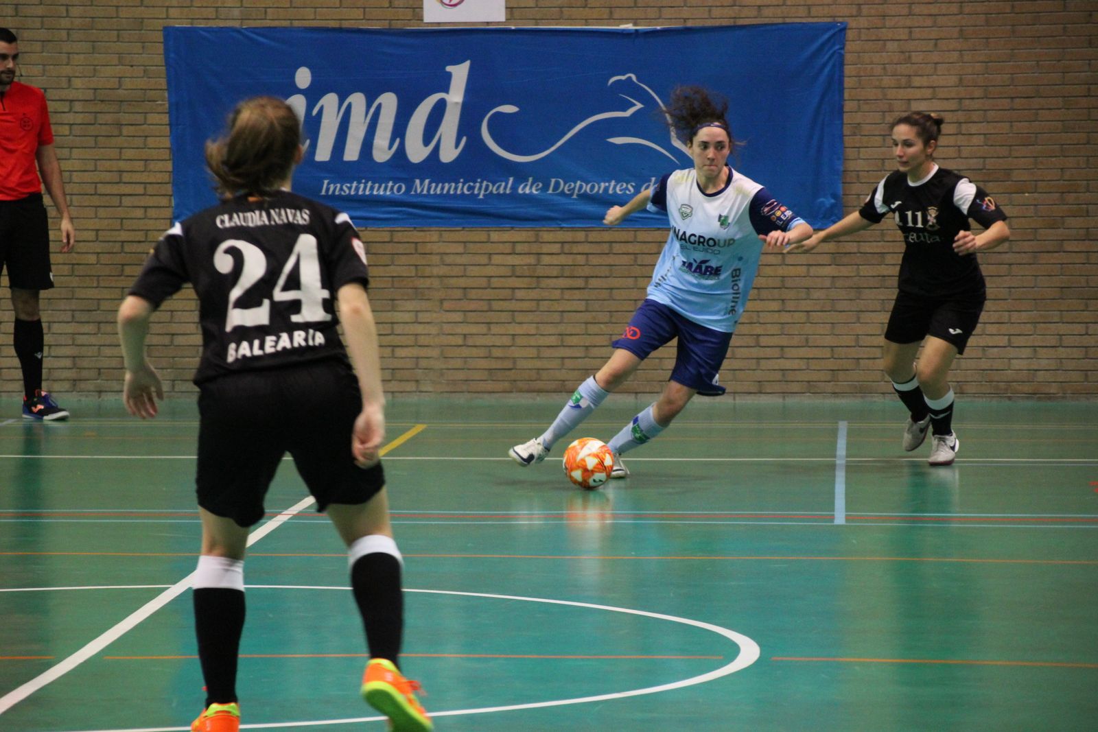 Una jugadora celeste conduce el esférico ante la oposición de una rival.