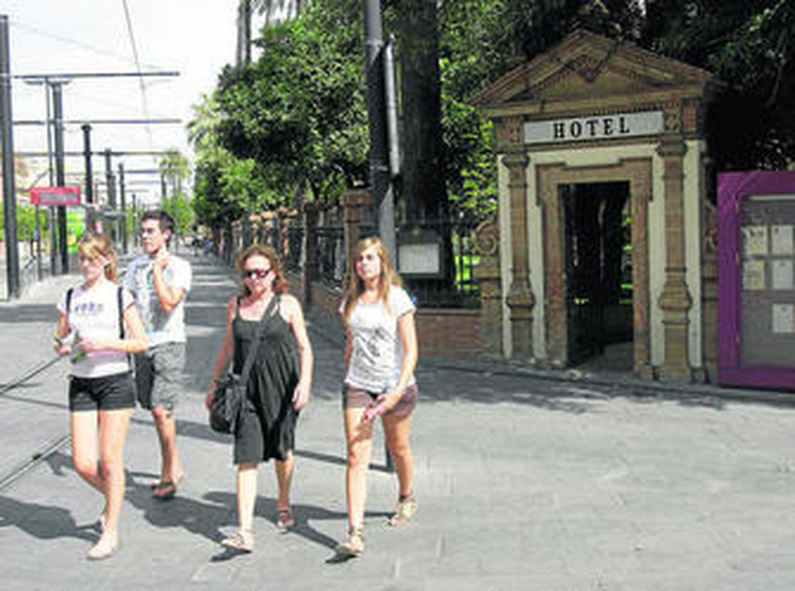 Una familia de vacaciones en Sevilla pasa junto a uno de los hoteles de mayor categoría de la ciudad.