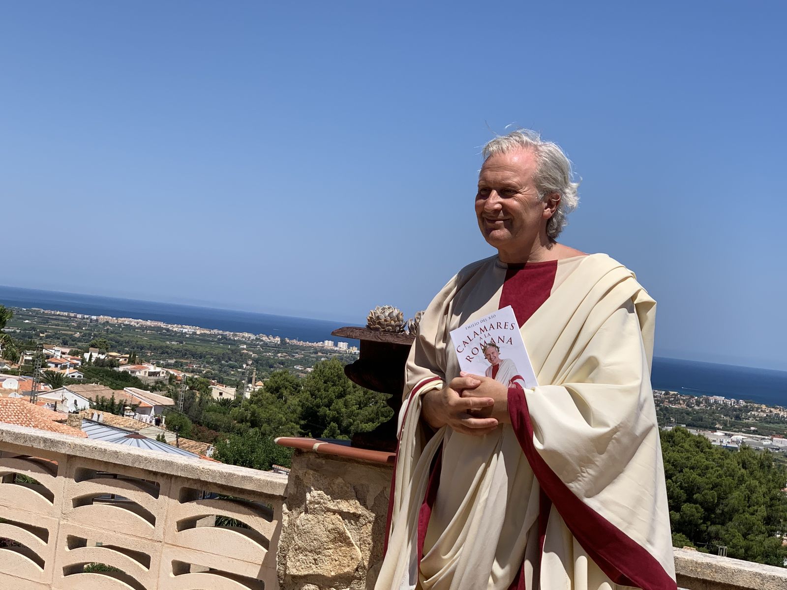 Emilio del Río, vestido de romano, con su nuevo libro sobre las manos.