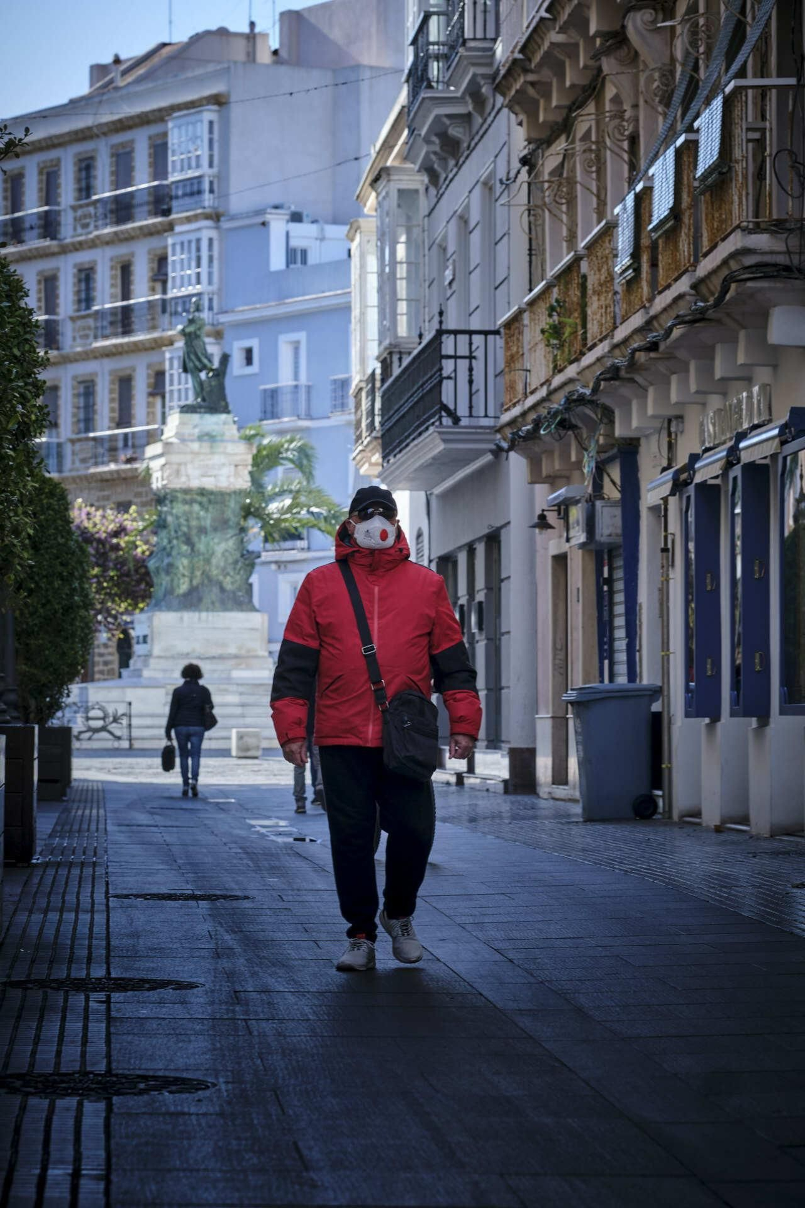 Un hombre camina protegido con mascarilla por la calle Nueva
