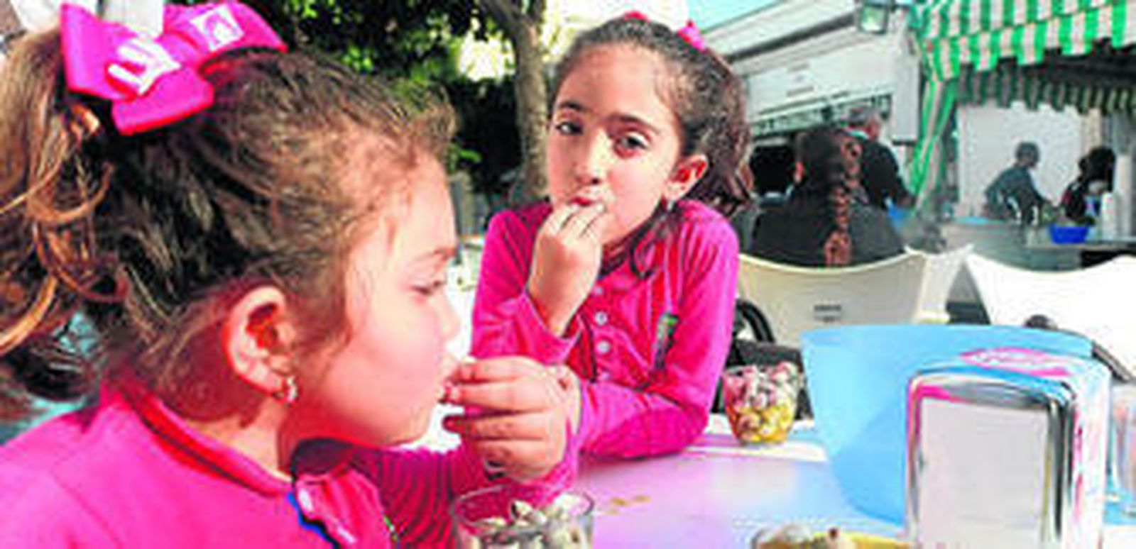 Dos niñas toman caracoles, ayer en el puesto de la plaza de la Magdalena.