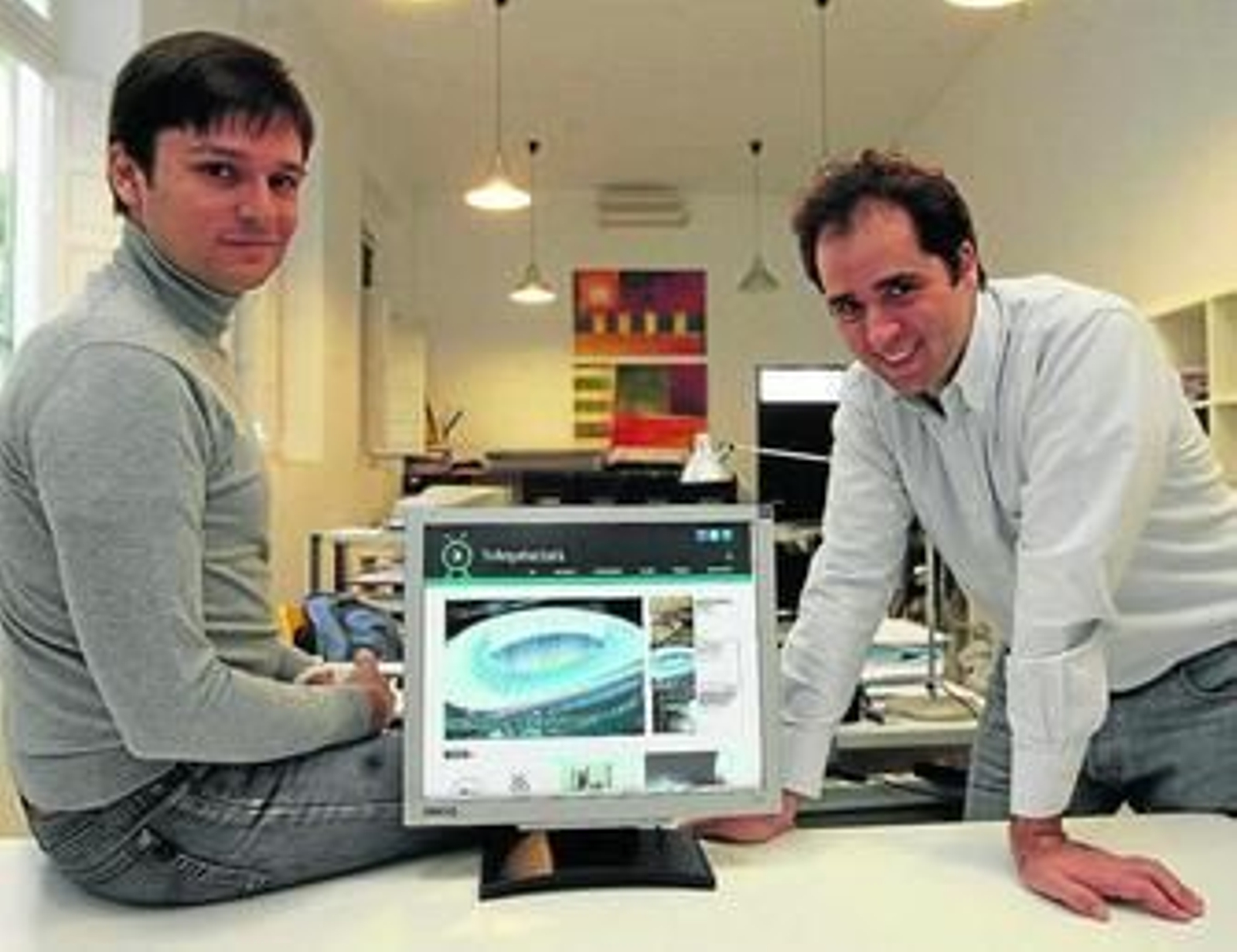 Alfonso Gómez-Feria (dcha.) y Carlos García, en su estudio y junto a la 'home' de su web en el ordenador.