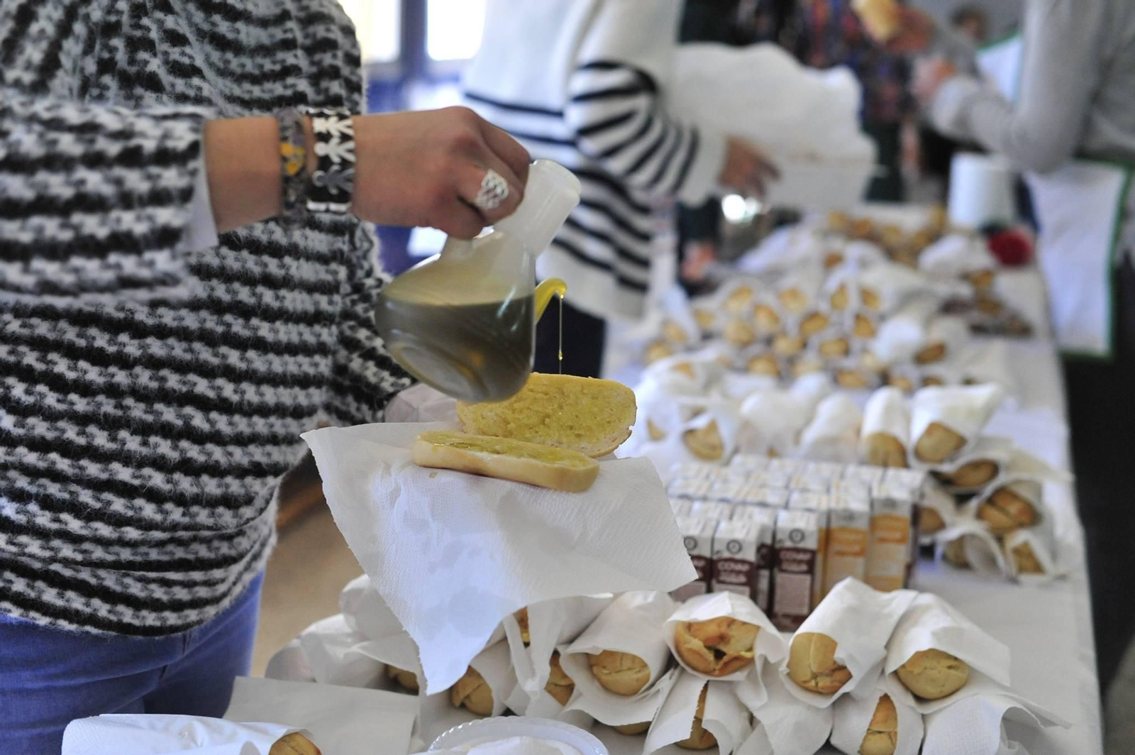 Preparando pan con aceite para la celebración de un desayuno con escolares.