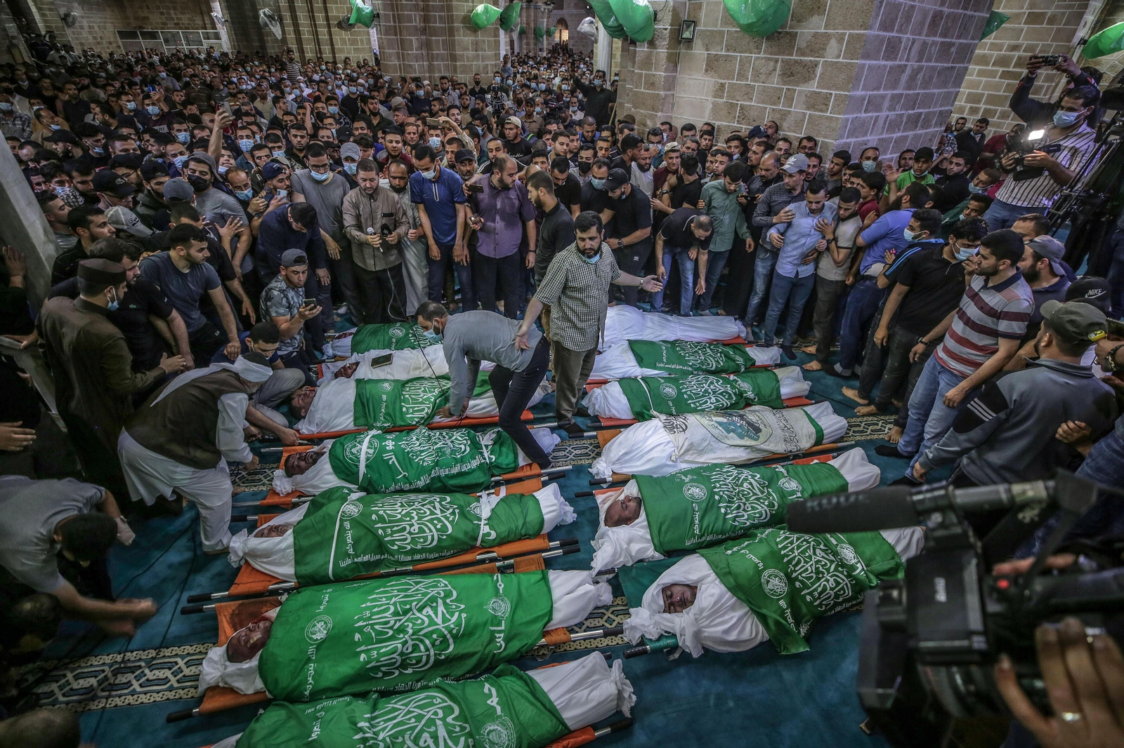 Varios palestinos yacen muertos en el suelo velados por sus compatriotas