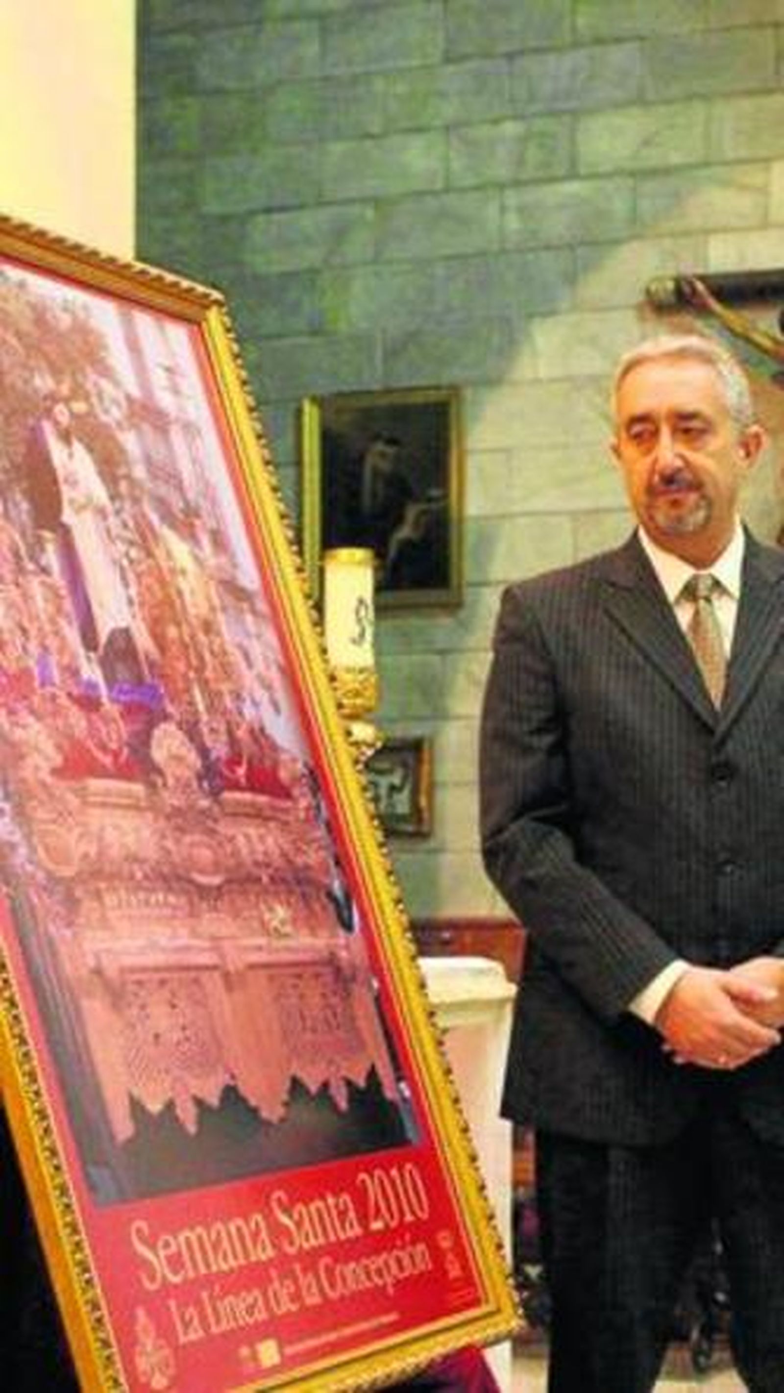 Antonio Cañete posa junto al cartel de Semana Santa.