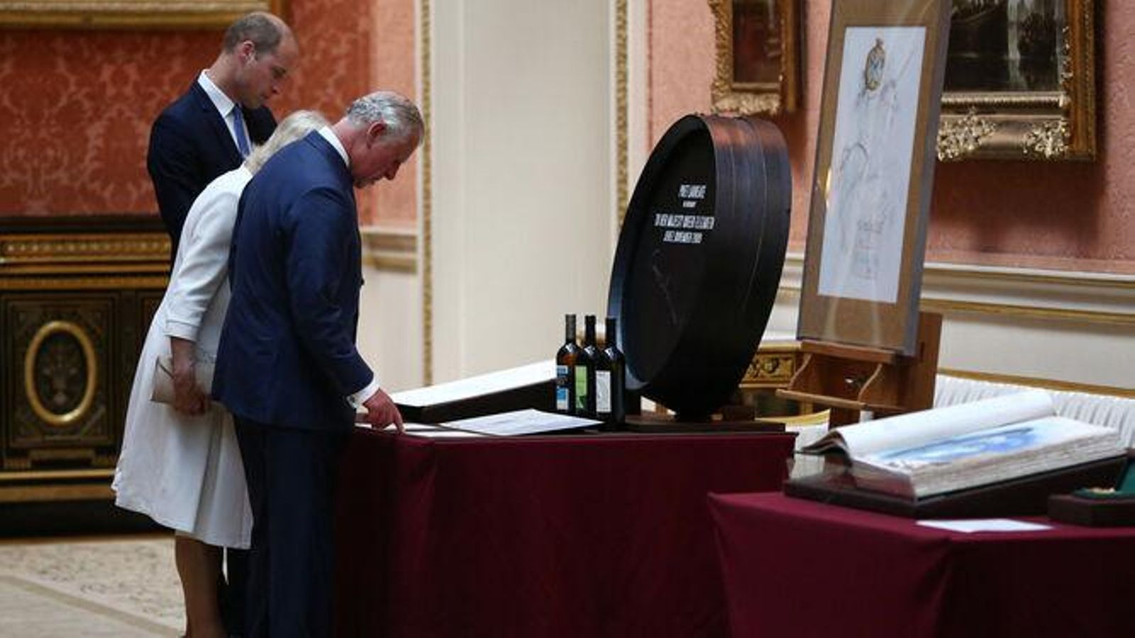 Los príncipes Guillermo y de Gales ante la réplica de la bota de los 'laureados'.