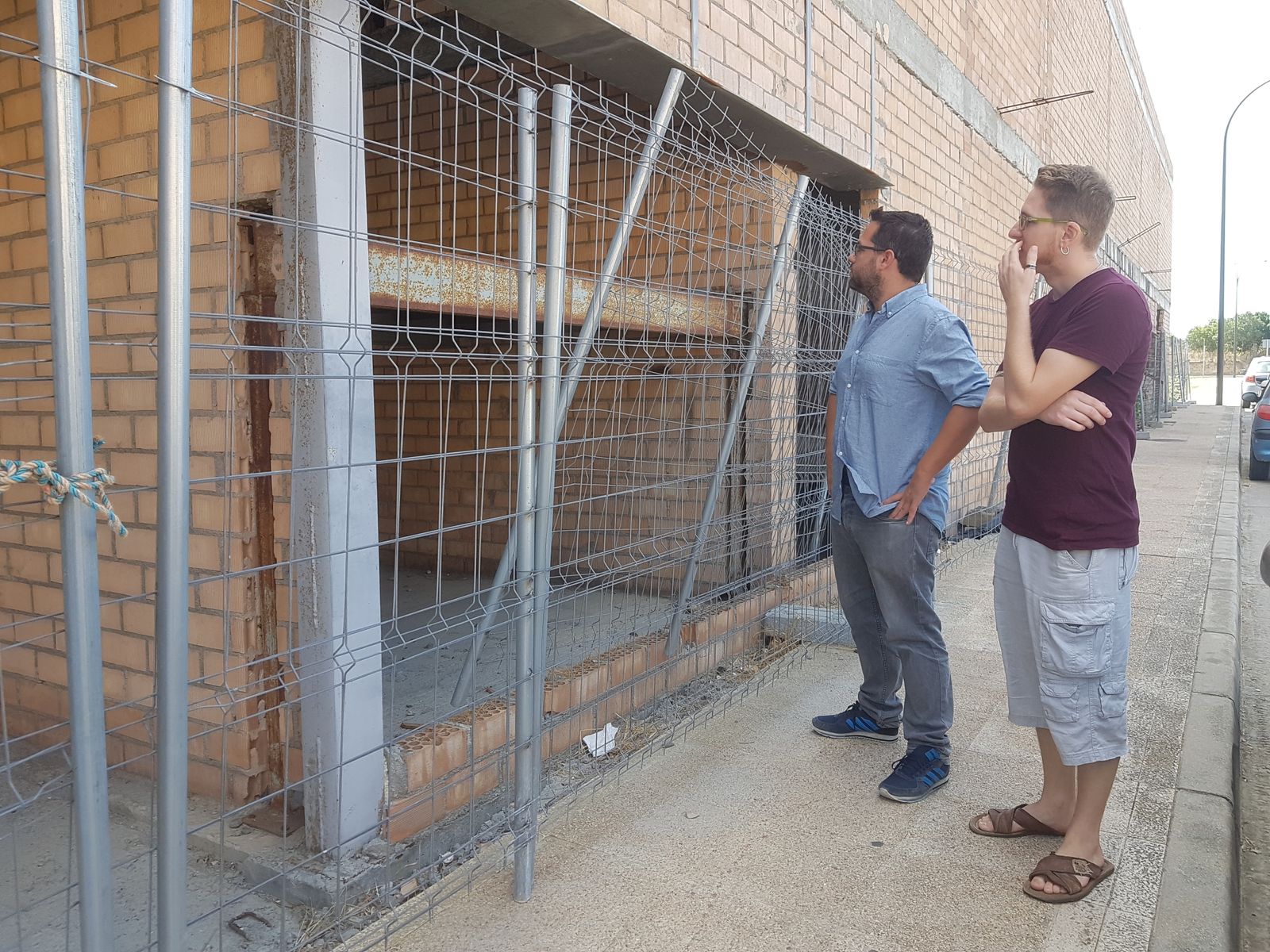 José Ignacio García (i.) y Ernesto Díaz observan el edificio a medio construir del centro de salud de Camposoto.