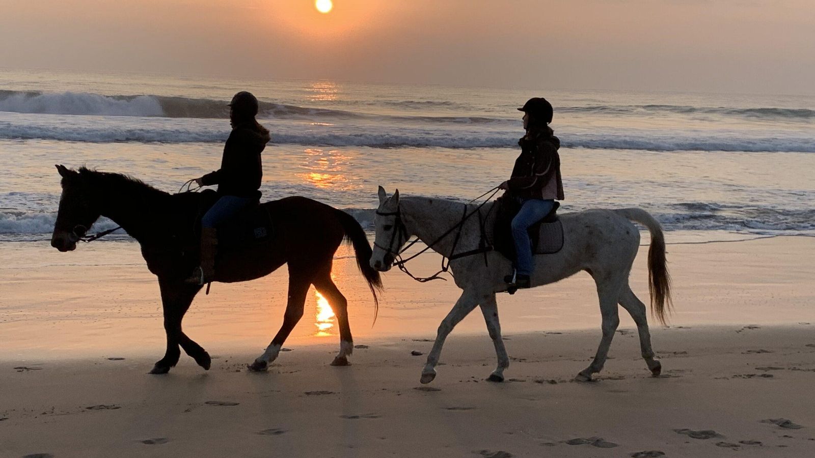 Paseo por la playa a la puesta de sol