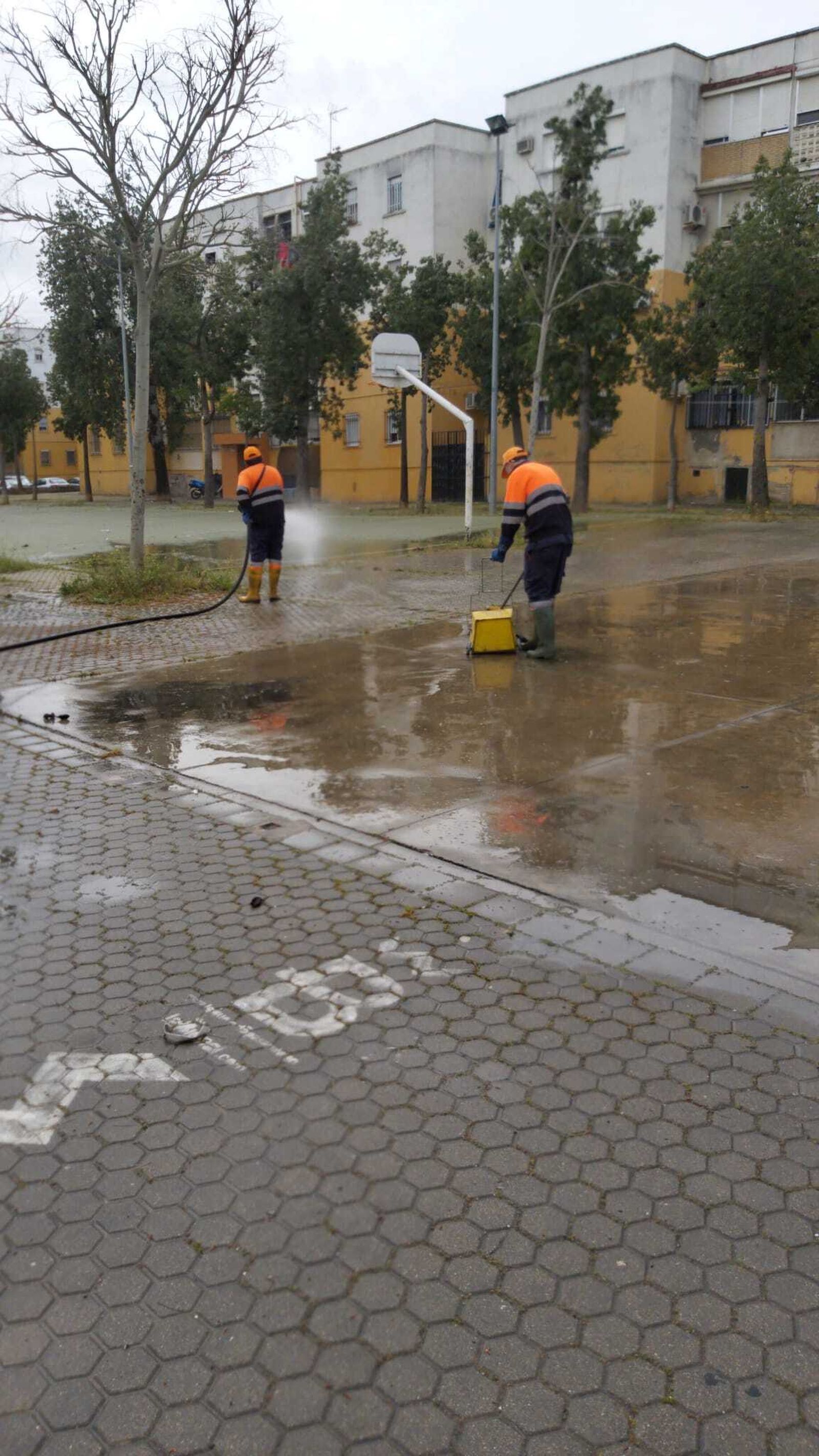 Dos trabajadores de Lipasam realizan tareas de desinfección en una pista de baloncesto.