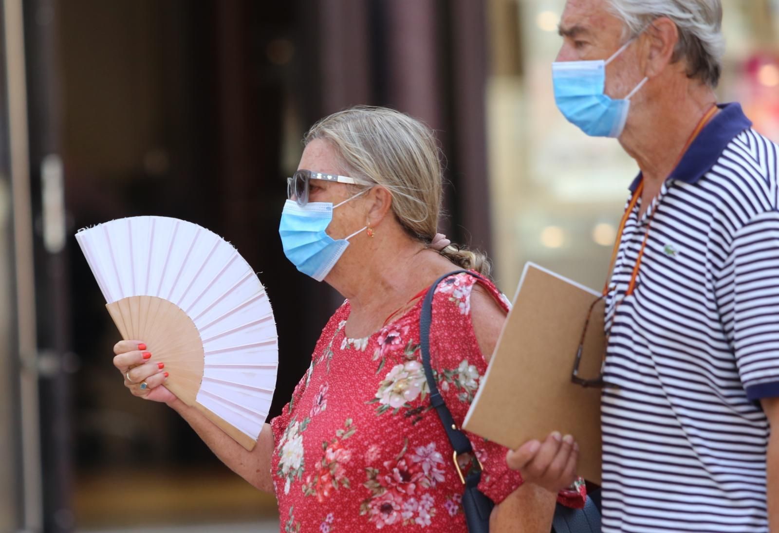 Dos personas pasean con mascarilla