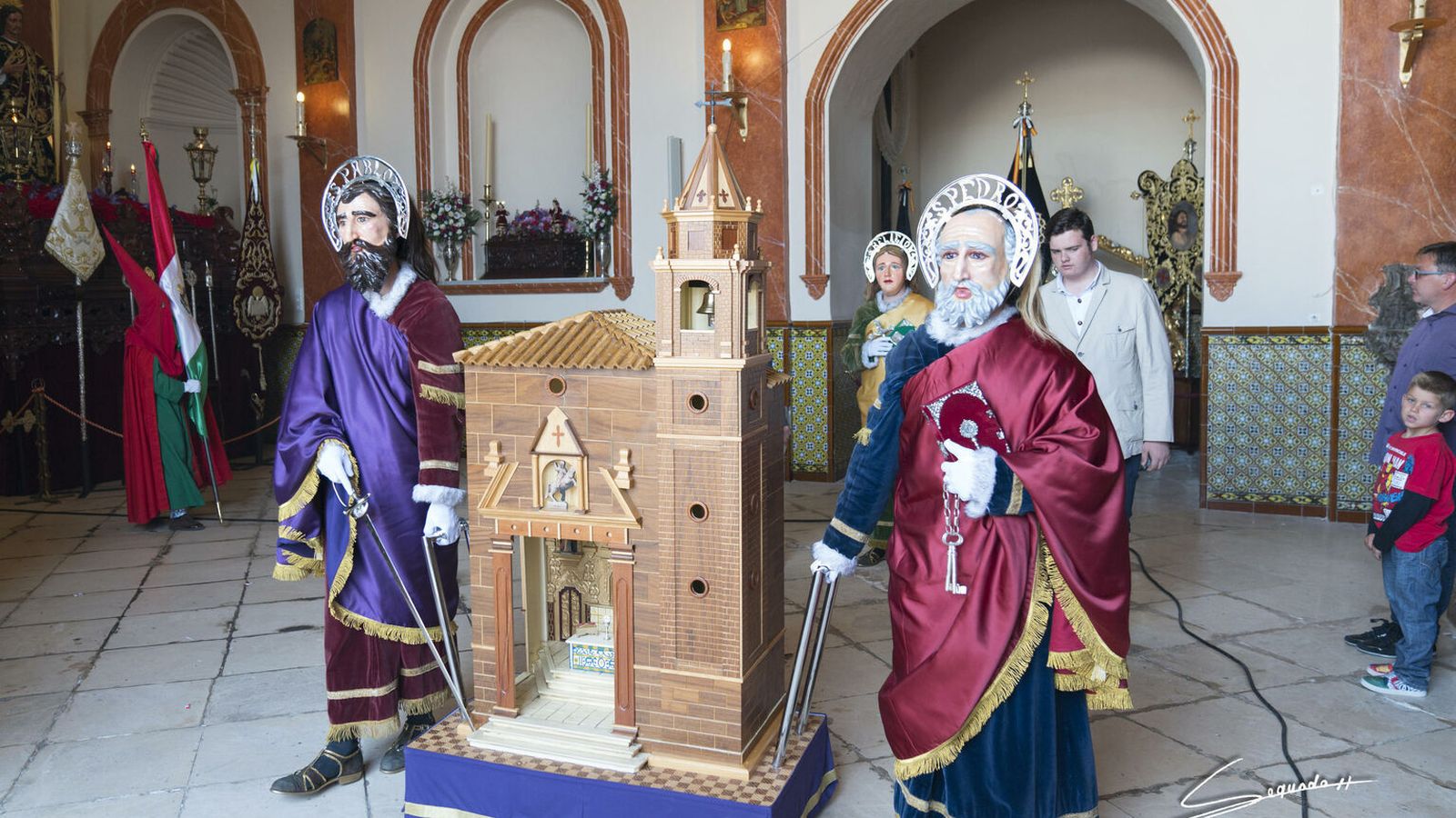 La corporación de los Defensores de Jesús, con  sus ropajes, símbolos alusivos y los característicos rostrillos.