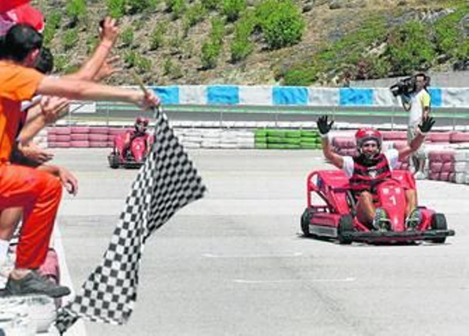 1. Julien Escudé levanta los brazos ante la bandera de cuadros del circuito de Jerez para celebrar su triunfo en la carrera de karts. 2. Negredo conduce su kart durante la carrera disputada ayer. 3. Escudé, Rodri y el utillero Manuel Galván celebran con champán sus puestos en el podio.