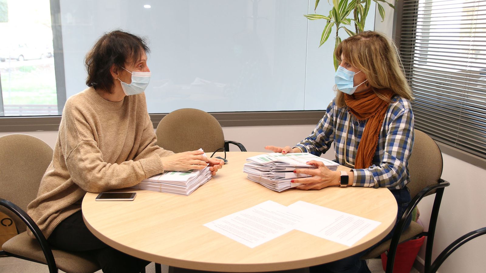 Julia Ibáñez (derecha) y Marga de León, con la documentación referida a la campaña de videollamadas.