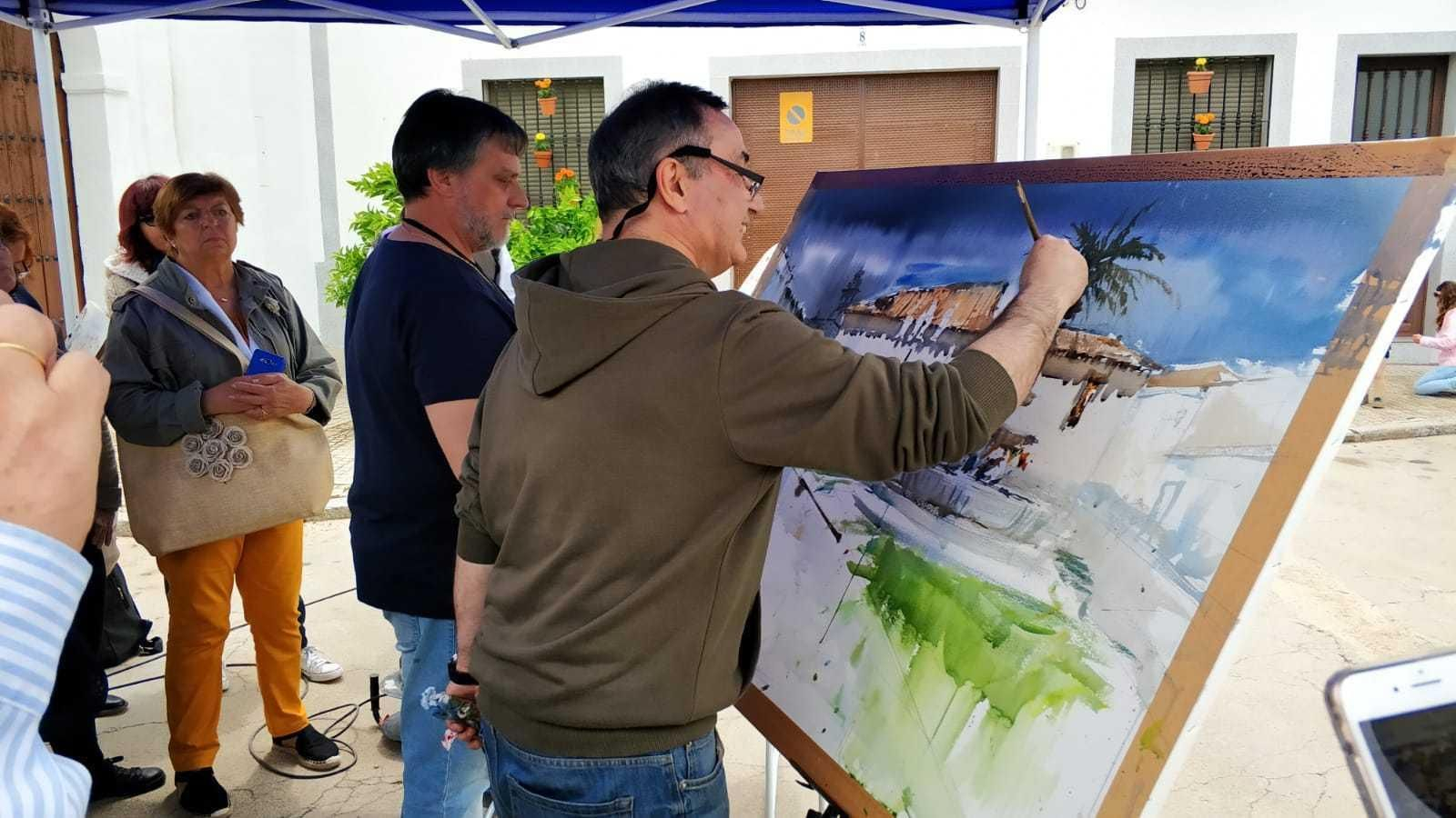 Dos artistas pintan una obra a cuatro manos.