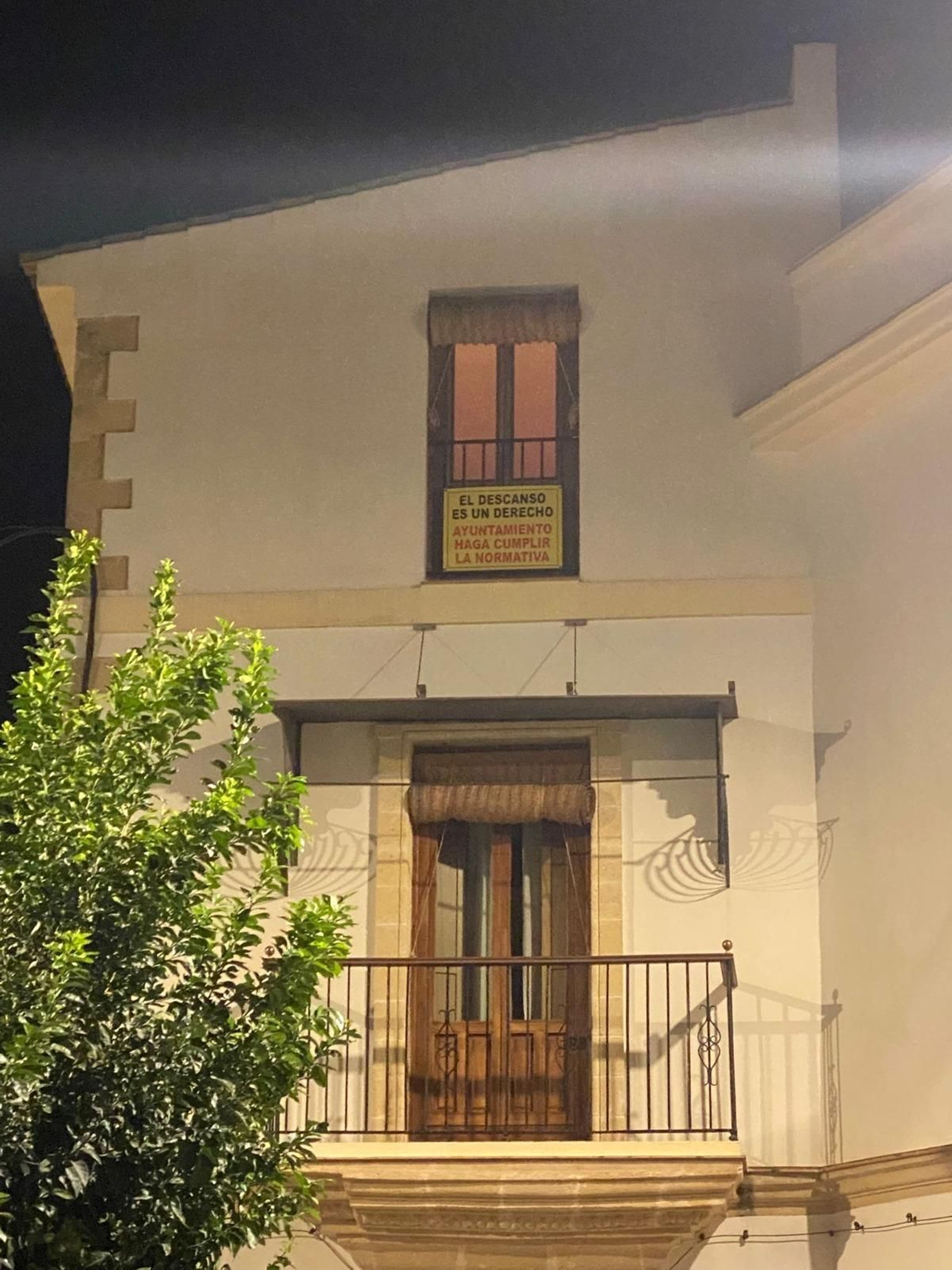 Balcón del centro histórico con un cartel de protesta.