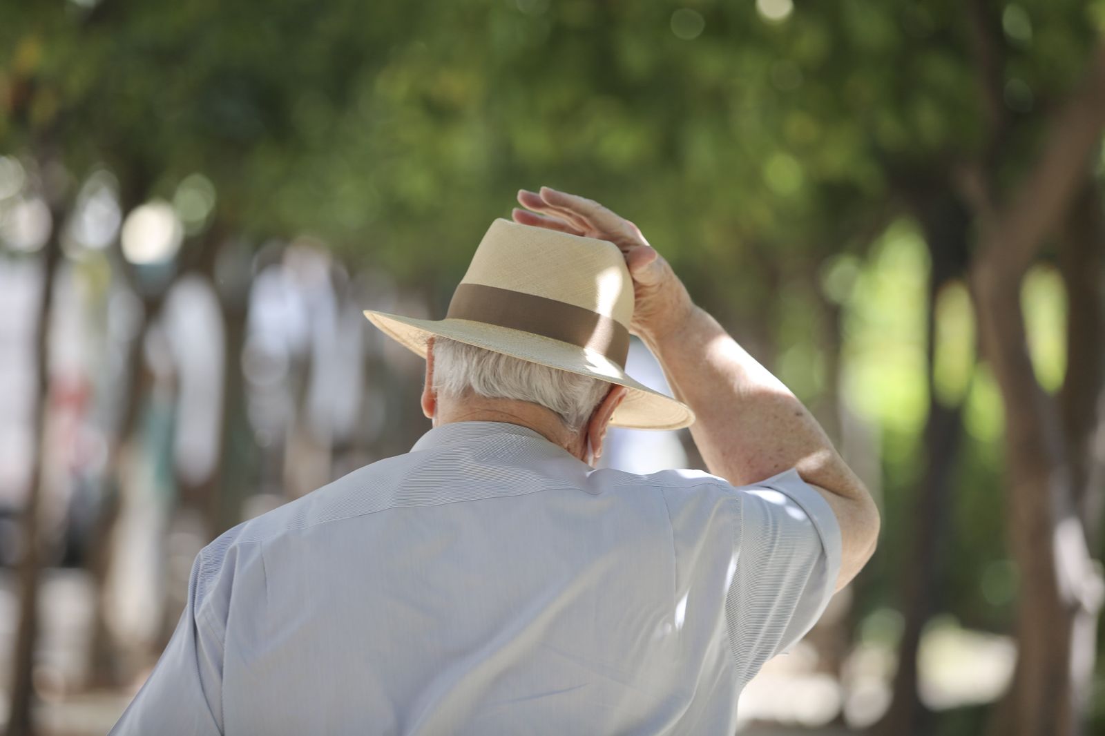 Un hombre sujetándose el sombrero, este viernes en Málaga, un día de calor y viento.