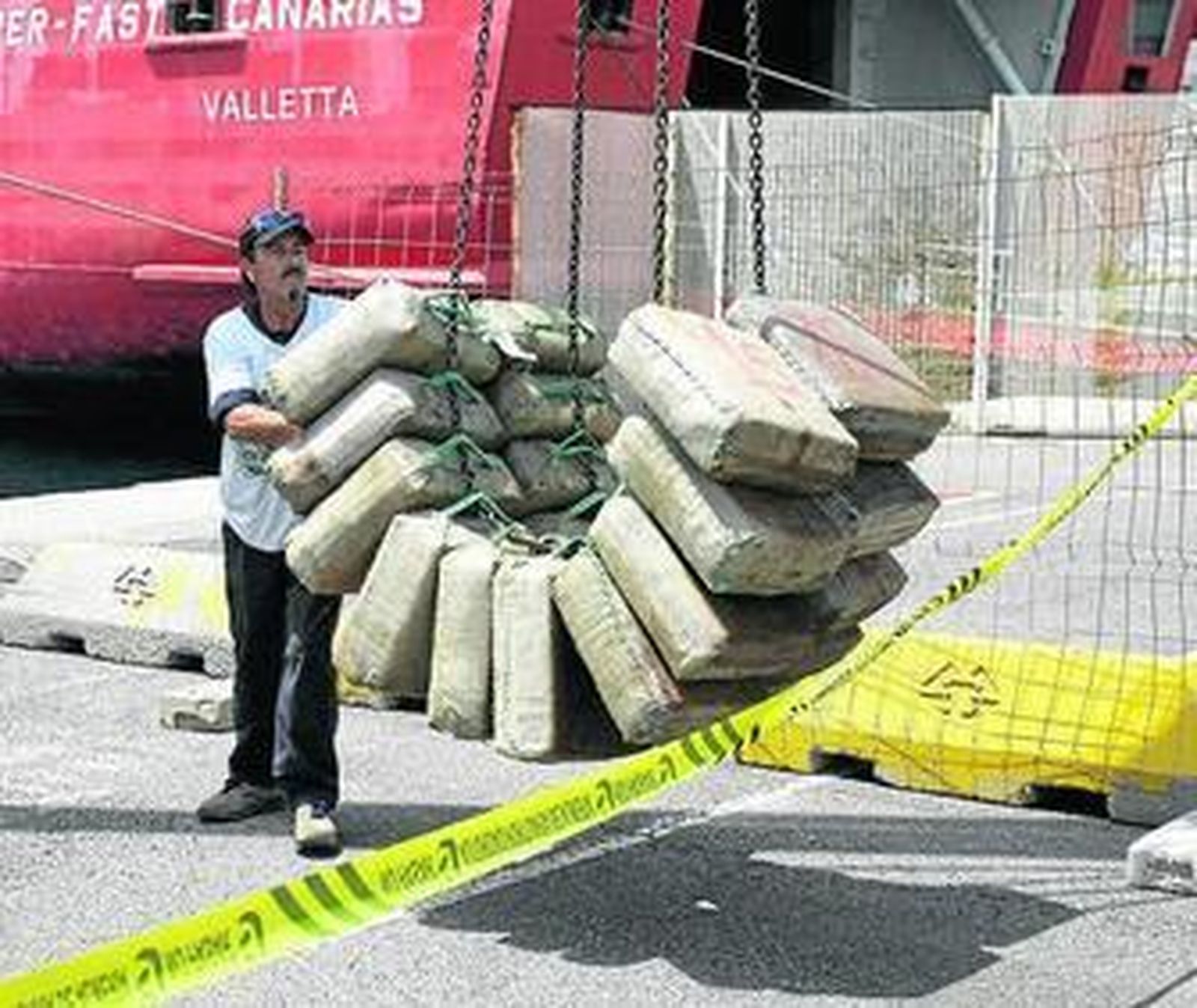 Descarga de los fardos de hachís localizados durante el registro.