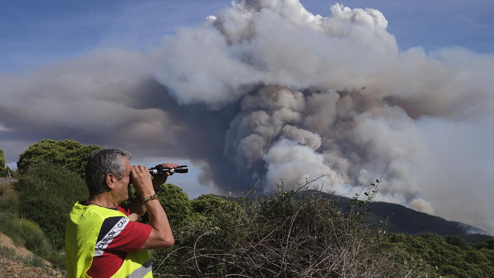 Un vecino de la zona observa la columna de humo.