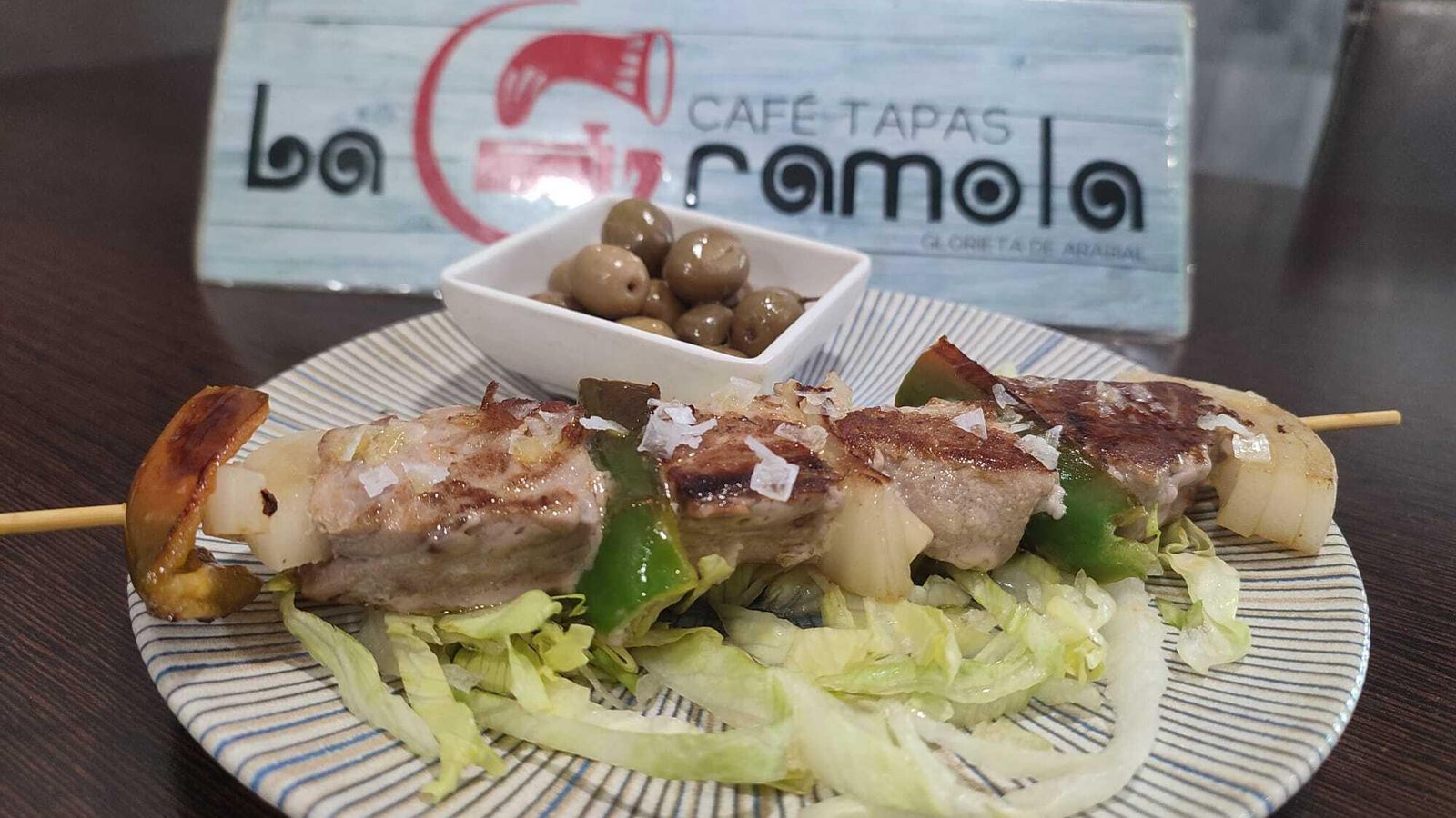 La brocheta de atún acompañada de aceitunas y ensalada.