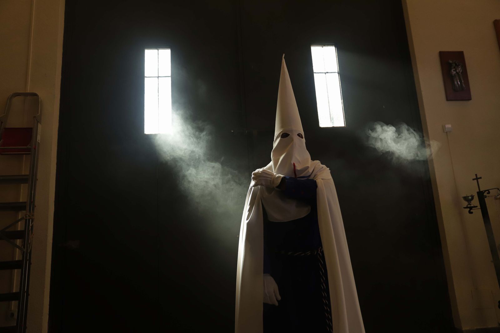 Un penitente se prepara para salir en un desfile procesional en Algeciras.