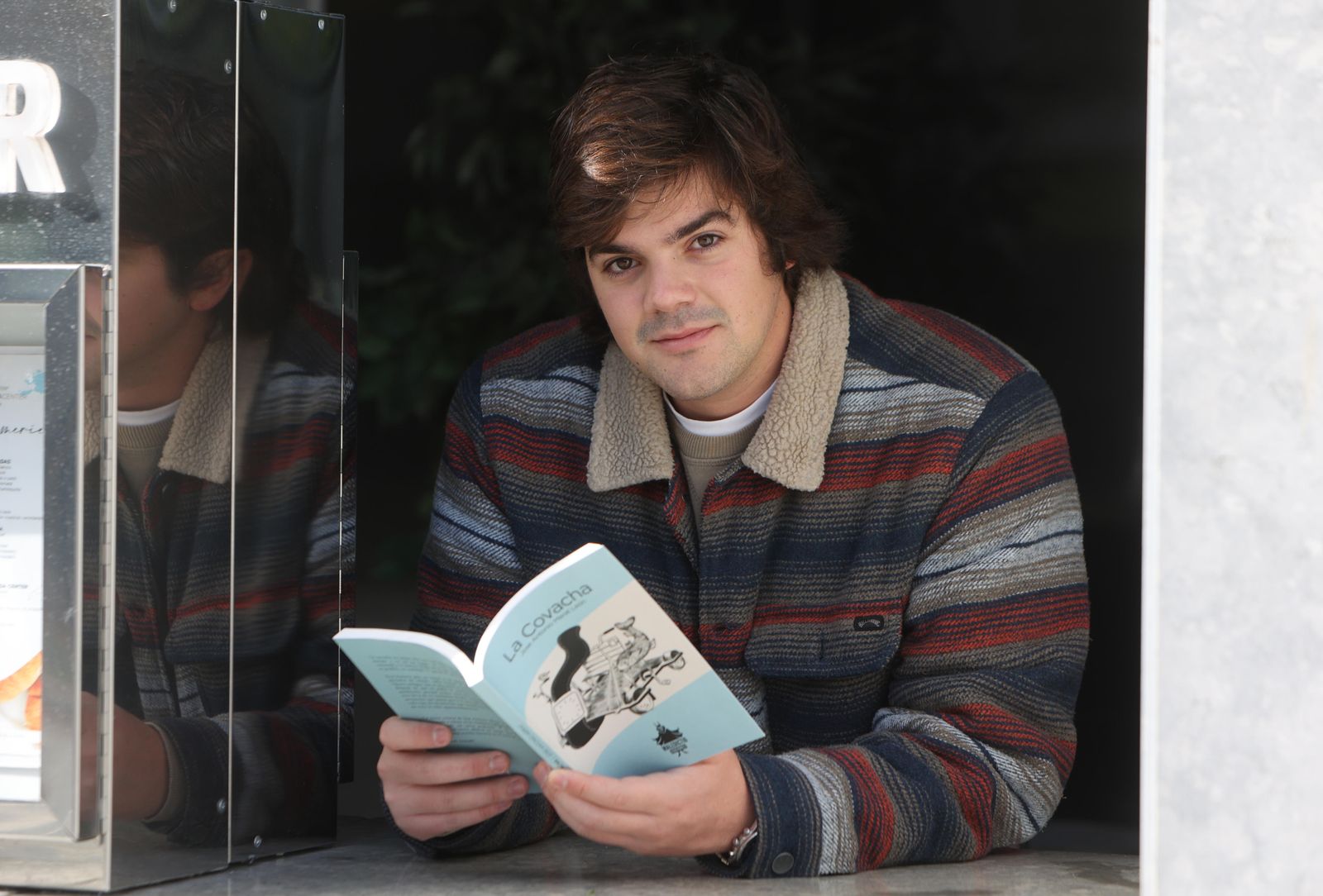 José Merat sostiene su libro, 'La Covacha'.