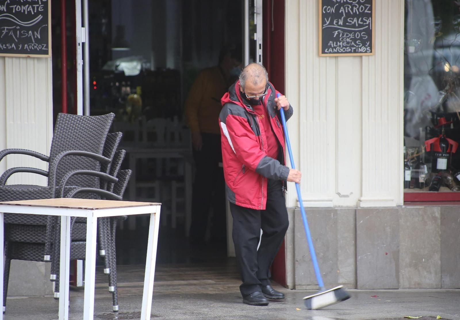 Un hombre, adecentando el acceso a un negocio del centro. Un hombre, adecentando el acceso a un negocio del centro.