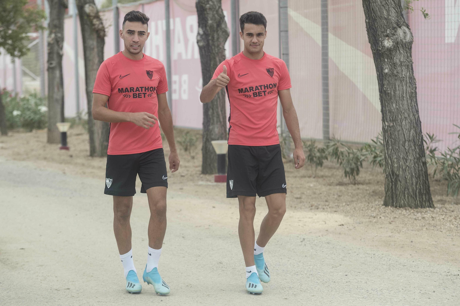 Reguilón saluda a los fotógrafos junto a Munir, al dirigirse al entrenamiento.