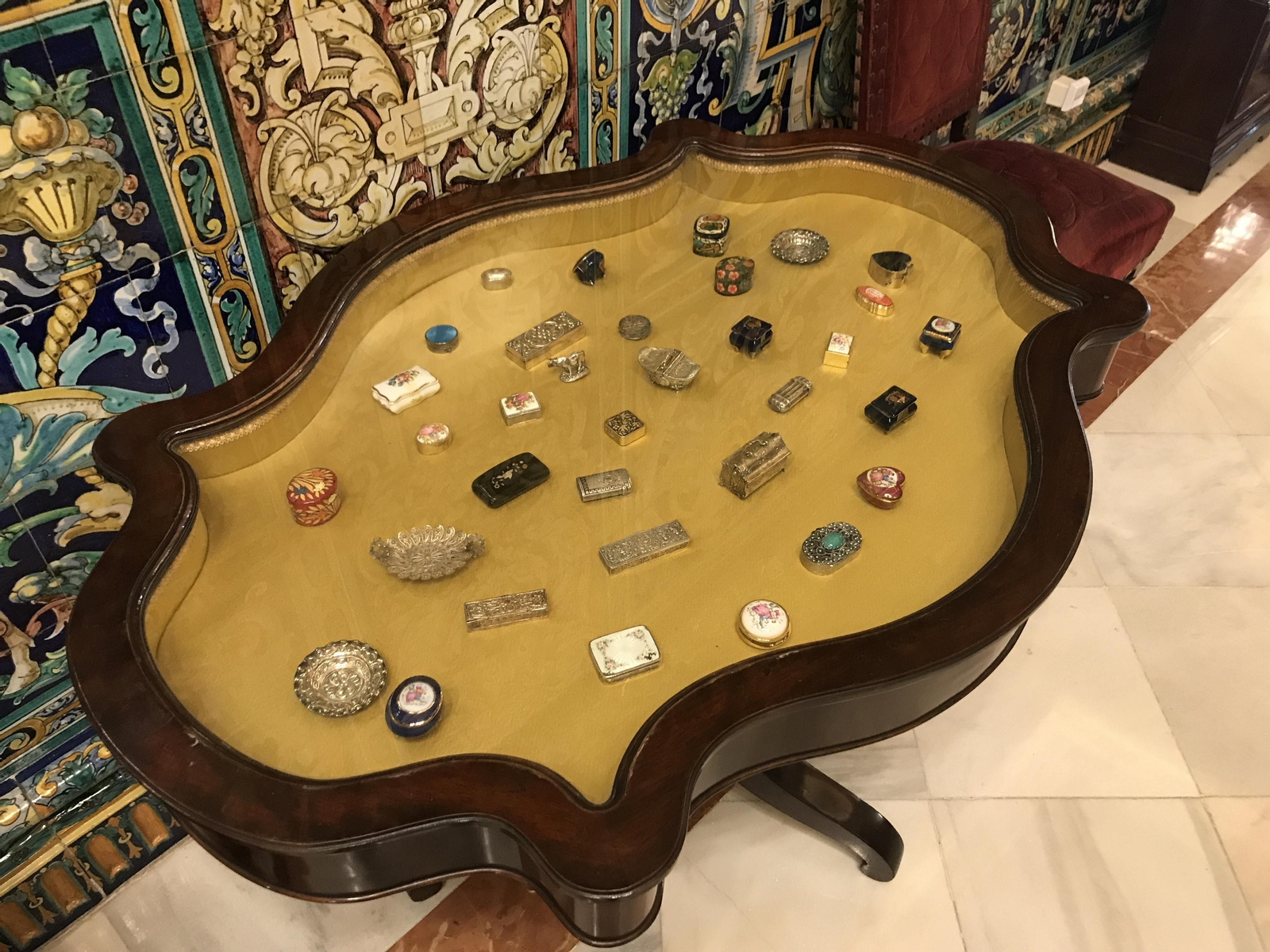 Mesa cristalera con una colección de cajitas en miniatura.